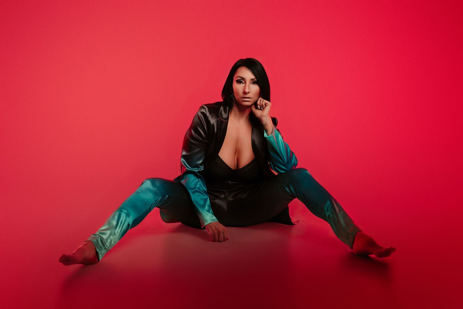 A person in a teal blazer poses against a vibrant red backdrop in a series of dynamic fashion shots.