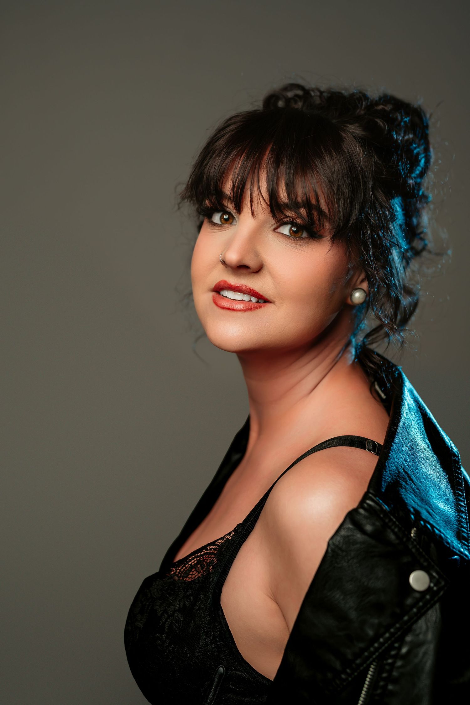 A portrait series showing different angles of a woman in black against a dark background with dramatic lighting.
