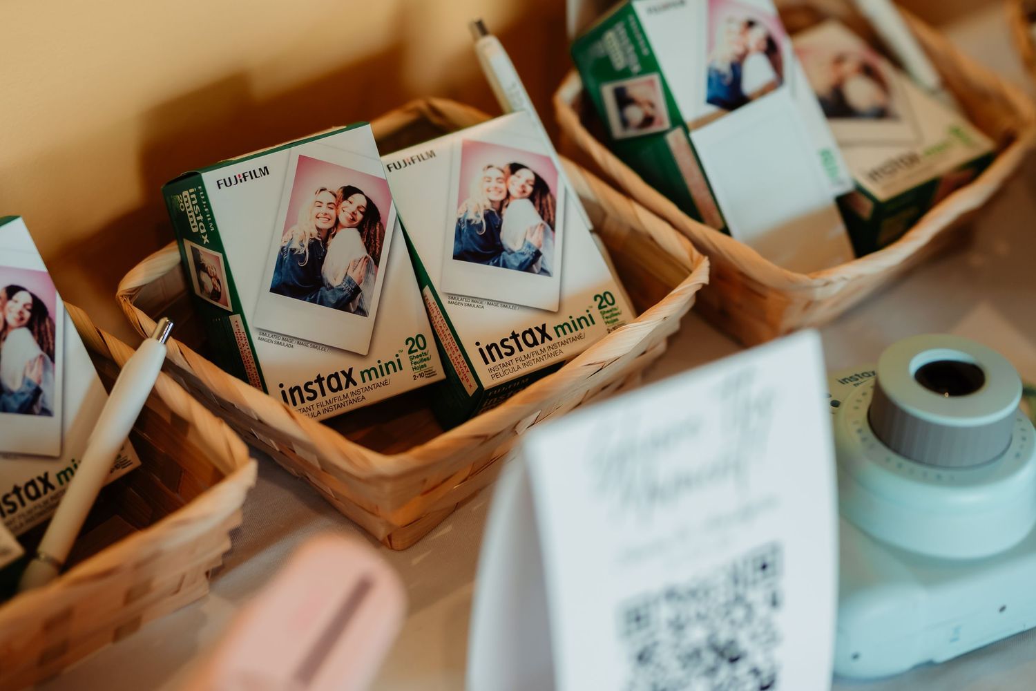 Wooden storage boxes filled with instant photos displayed next to a mint green camera.