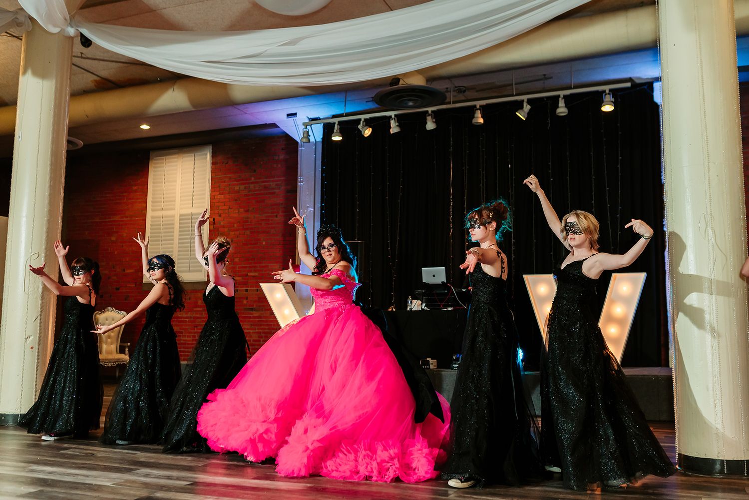 Dance performance on stage with bright pink tulle costumes and dramatic lighting effects.