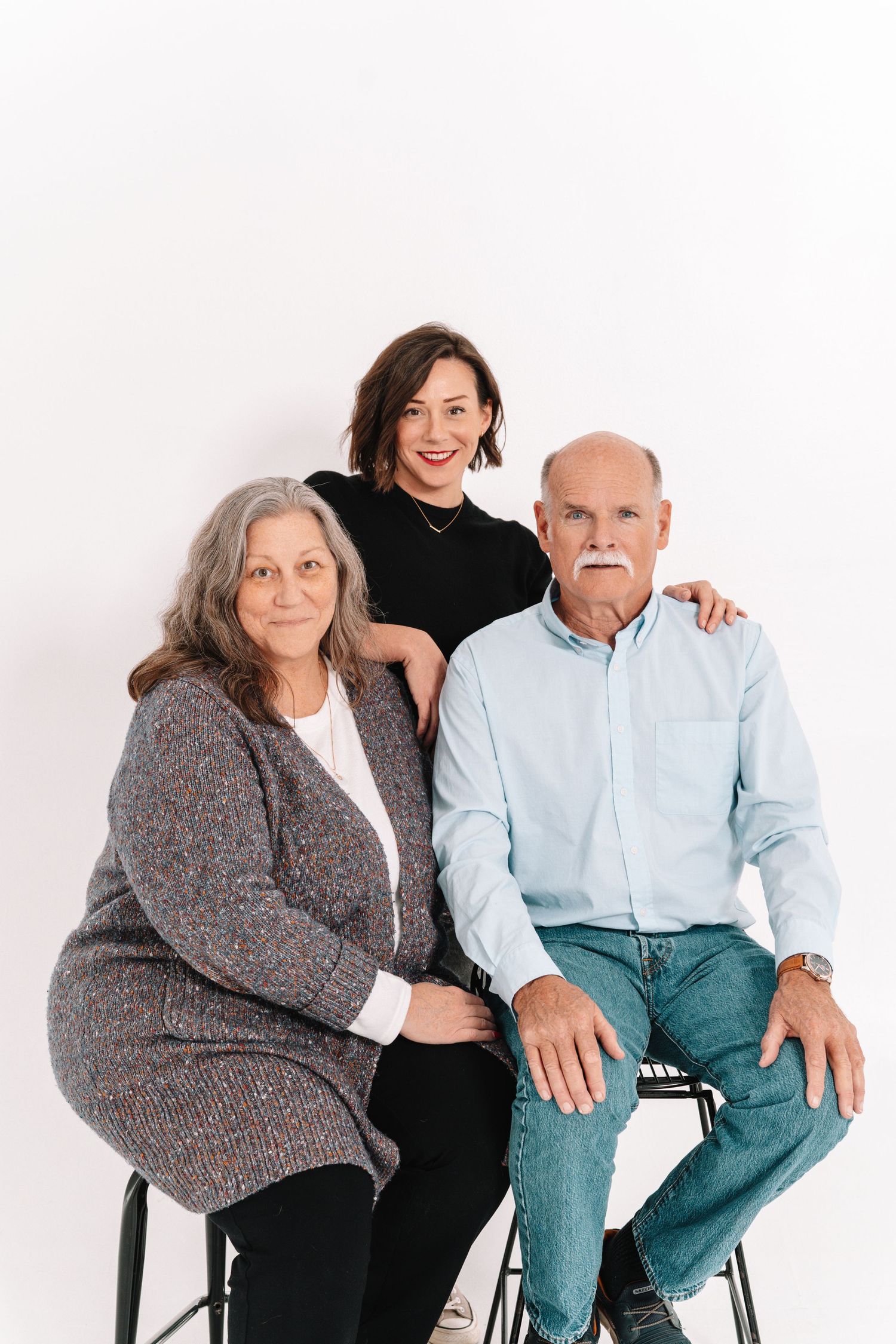 Four candid photos showing two people sitting together on chairs against a white background.