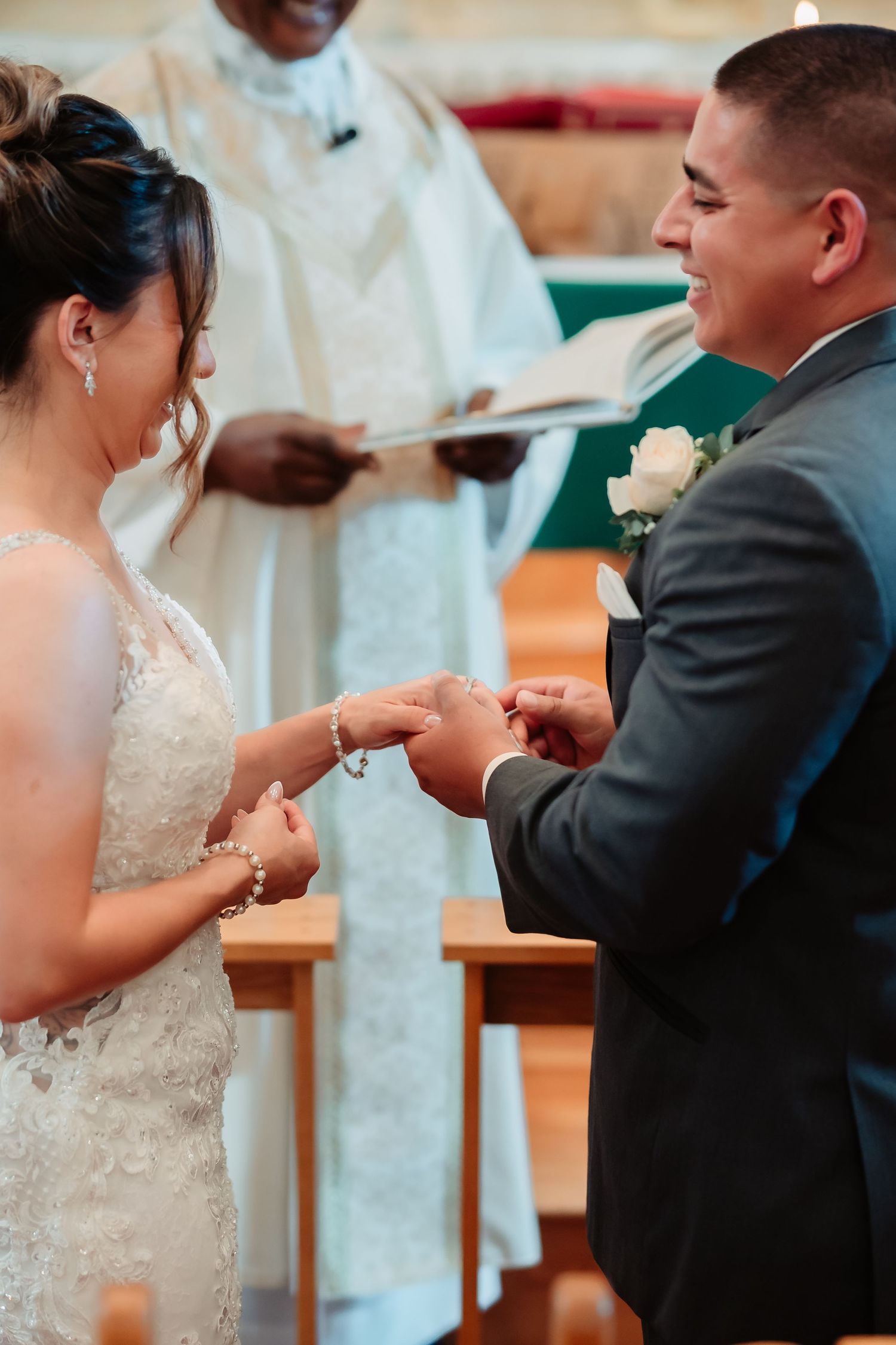 Wedding ceremony exchange of rings at church altar.