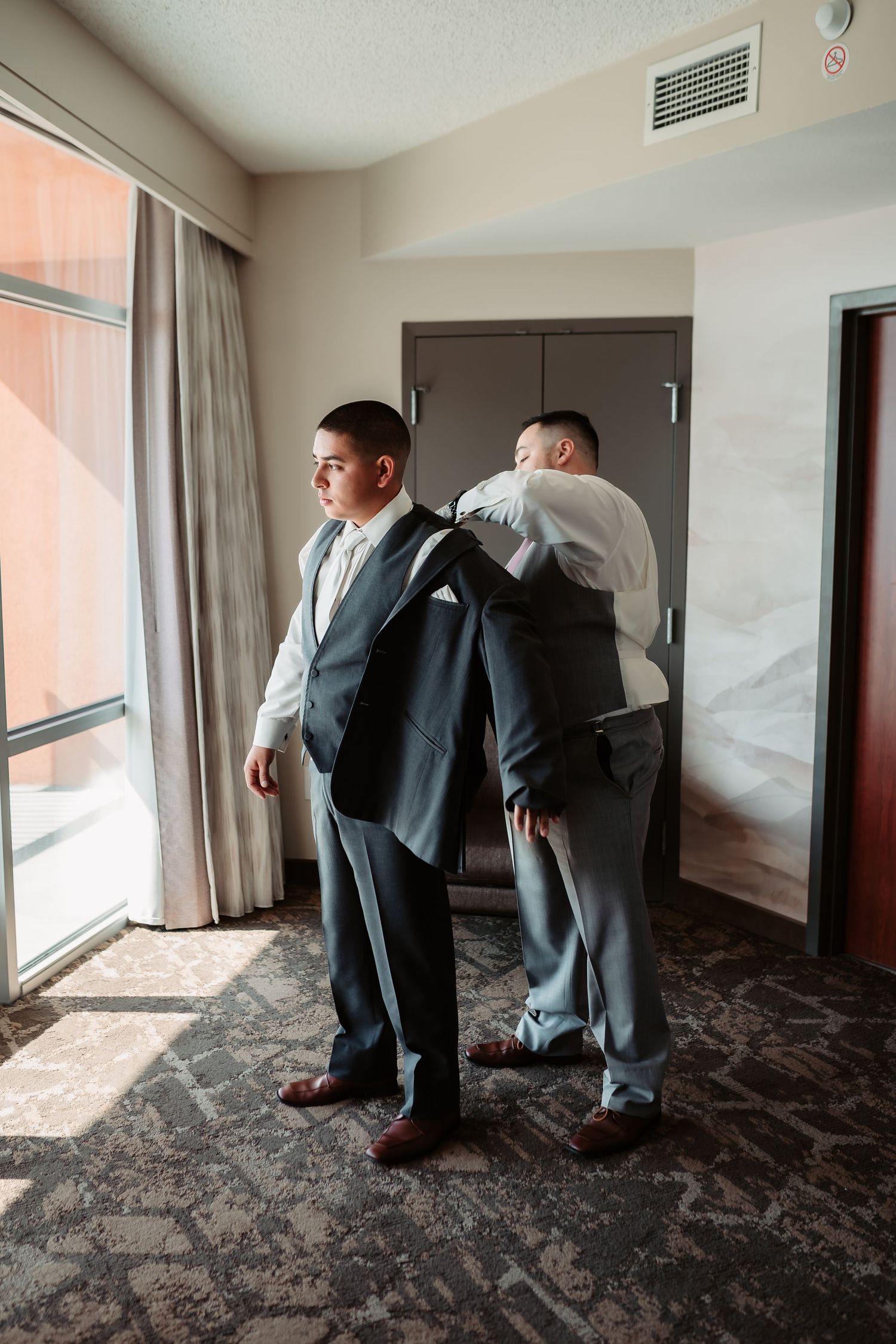 Sequence of formal preparation shots showing adjustments to dress shoes and suits in a hotel room.