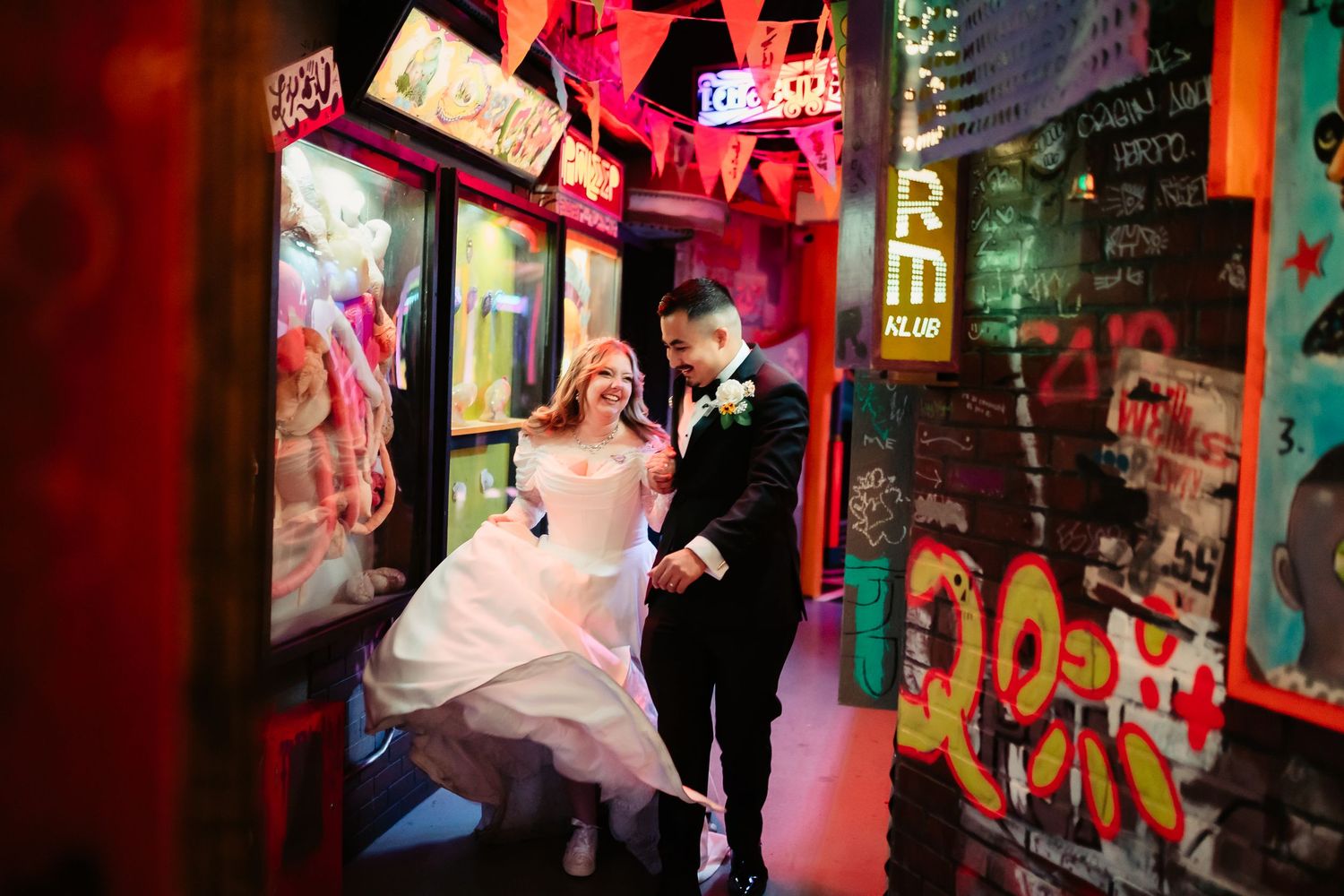 A series of colorful neon signs and illuminated storefronts at night create a vibrant urban atmosphere.