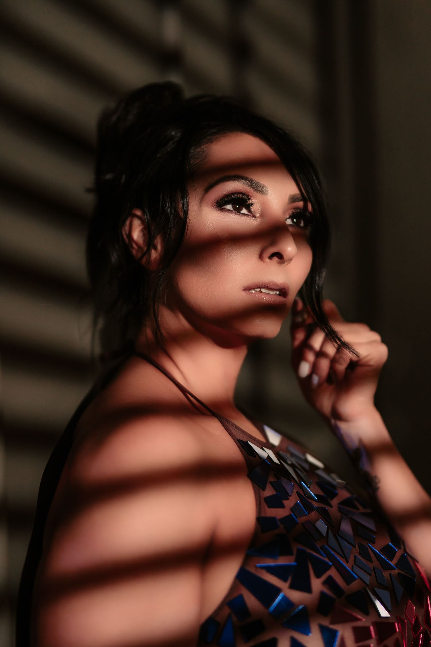 Artistic portrait with dramatic lighting and shadows creating a moody atmosphere with patterned clothing.