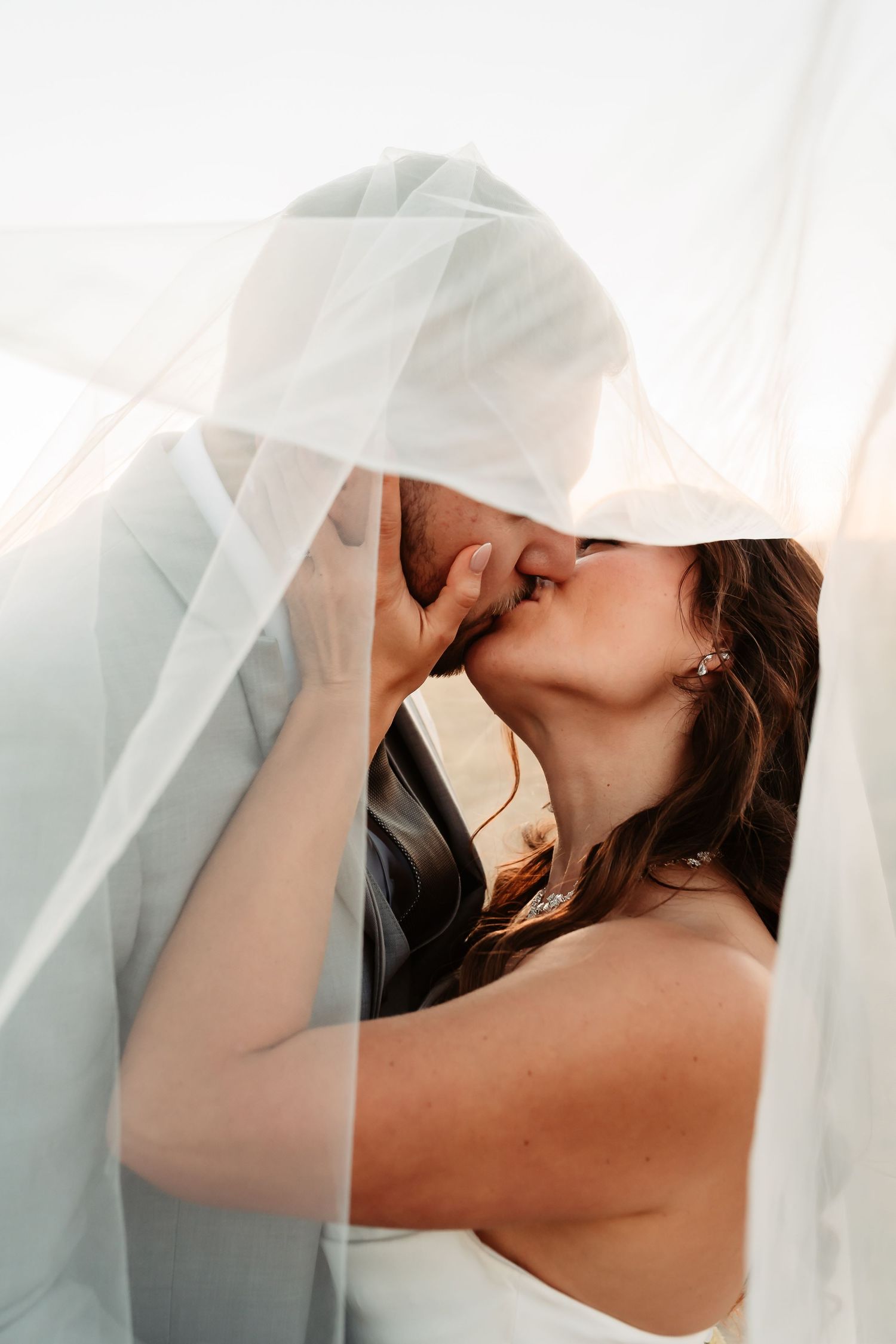 A figure draped in soft white sheer fabric creates an ethereal and romantic artistic portrait series.