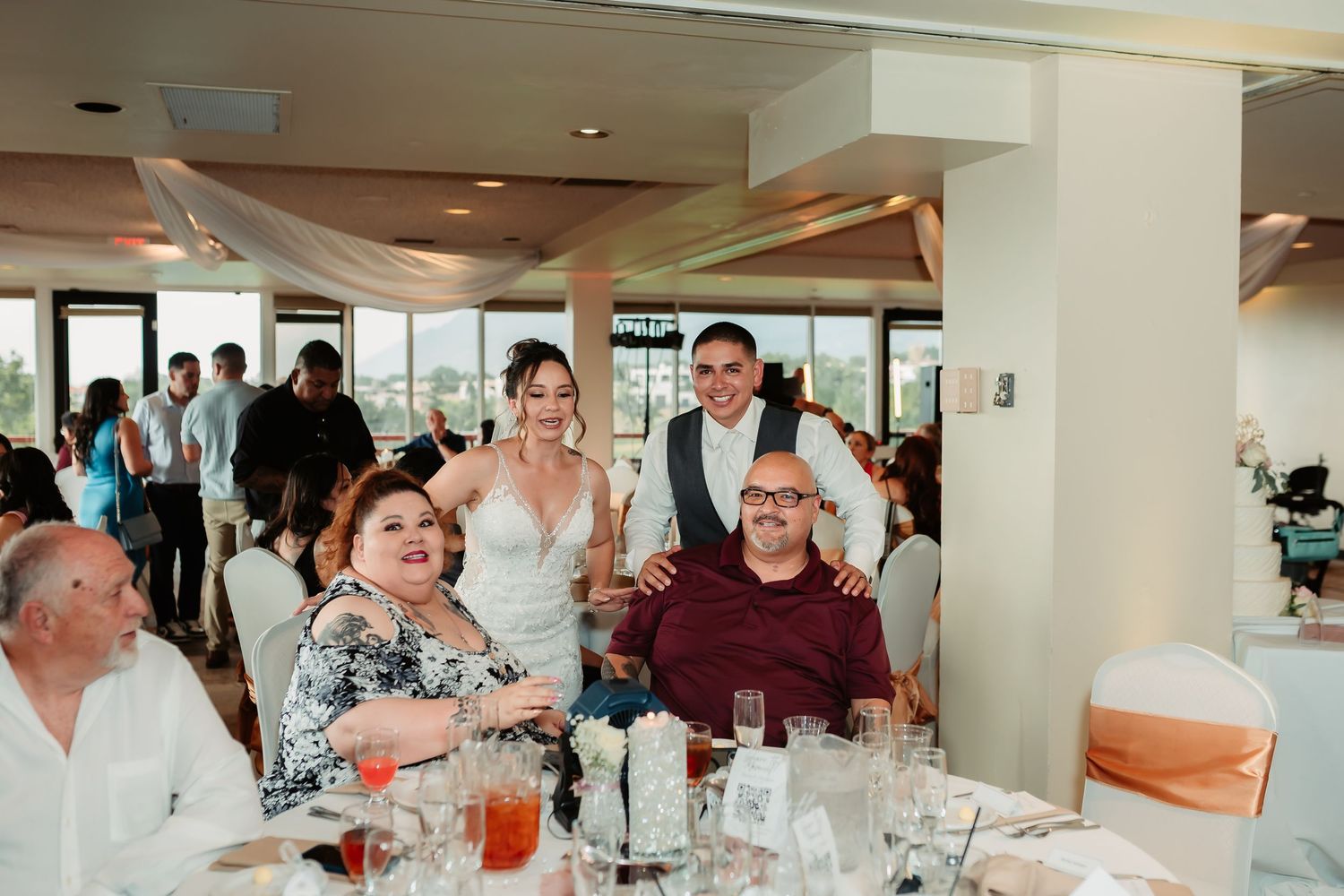 People gathered around tables at a casual dining event with drinks and conversation in an indoor venue.