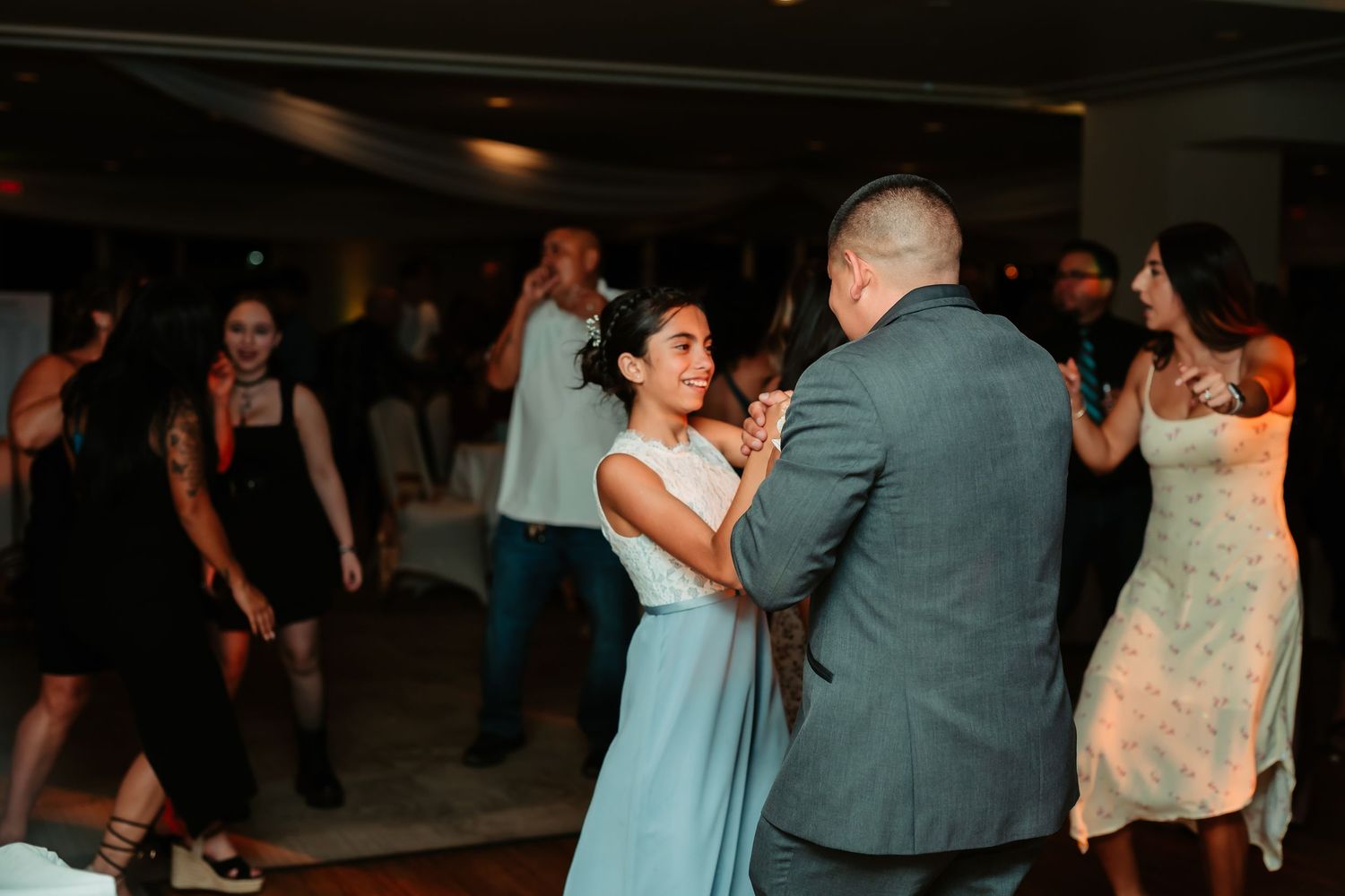 Couples slow dance during an elegant wedding reception with blue and gray color scheme.
