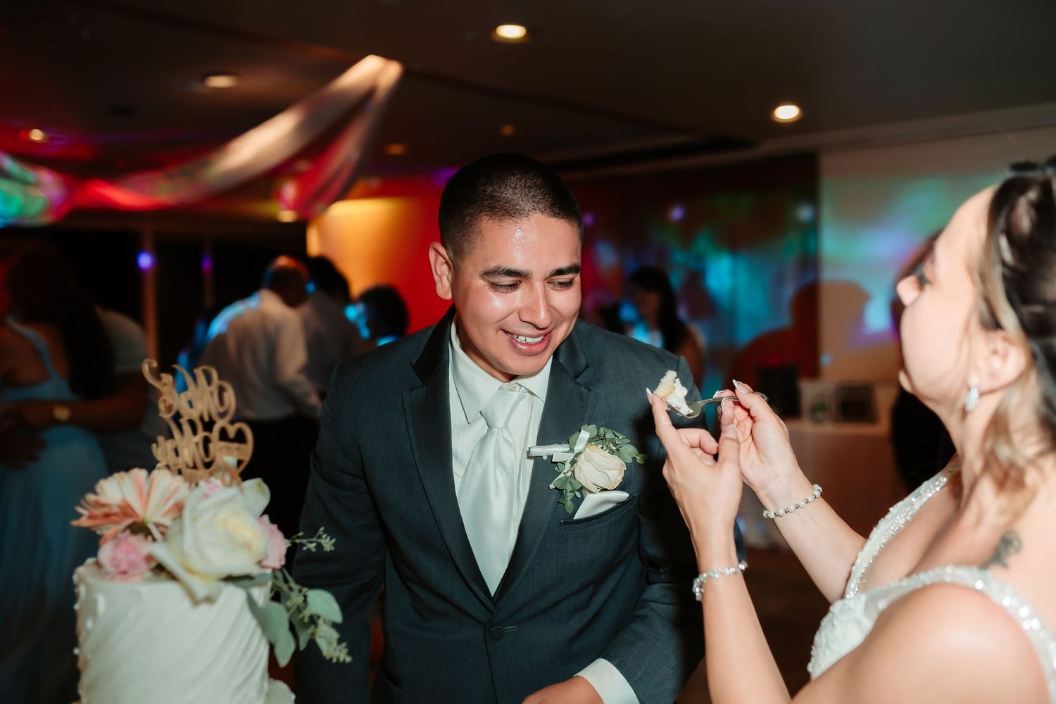 Wedding couple laughs together during their cake cutting ceremony at the reception.