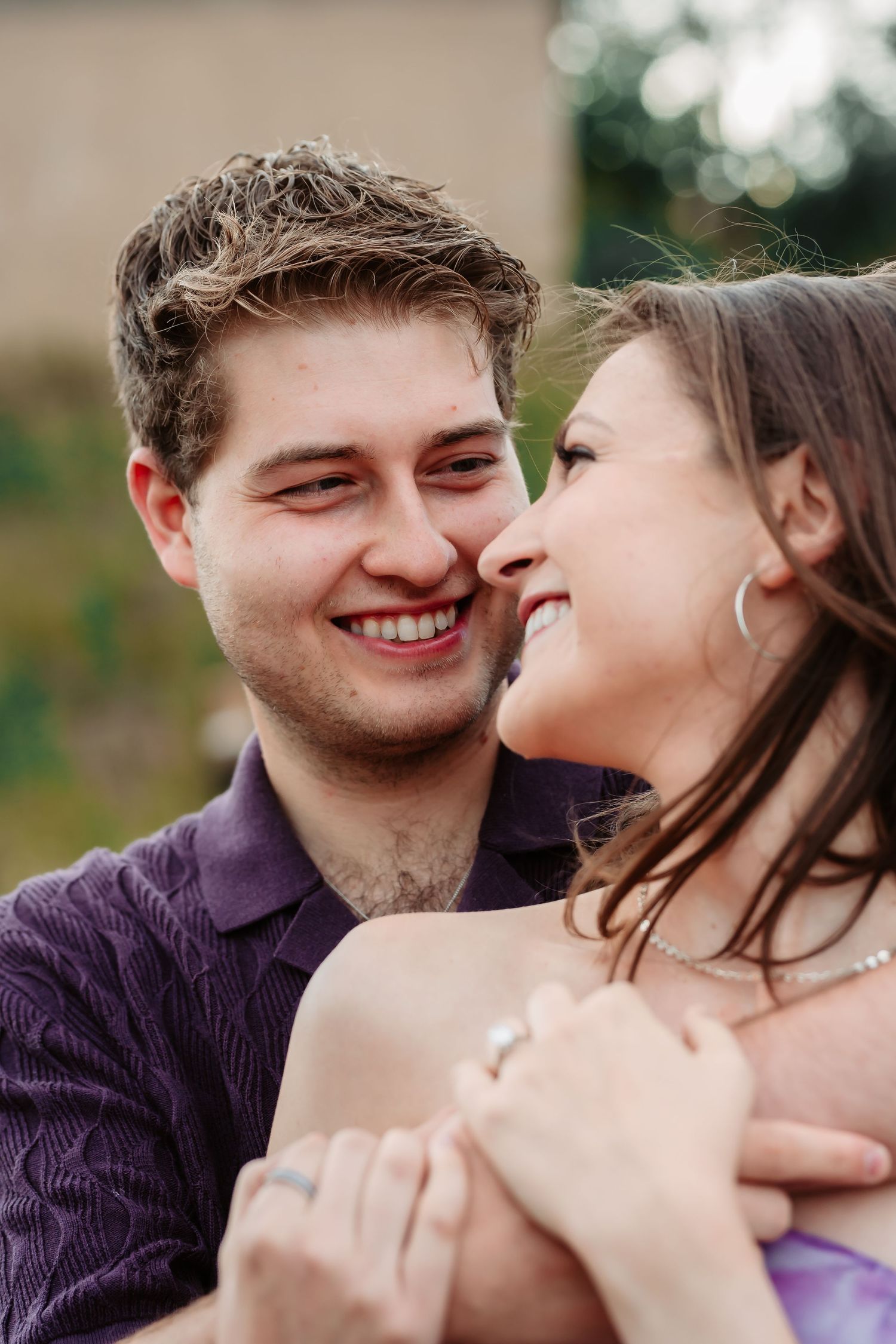 Intimate close-up shots of couple sharing joyful moments during outdoor engagement session.