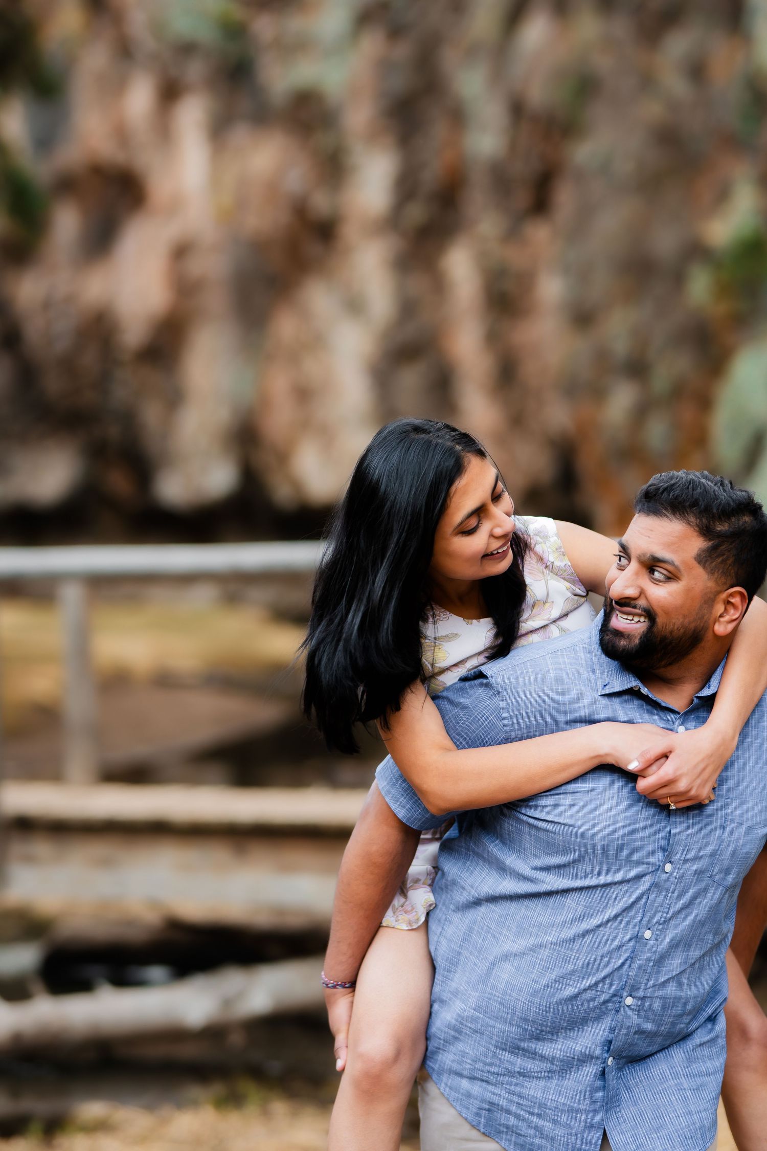 A joyful piggyback ride moment captured against rugged cliff scenery.