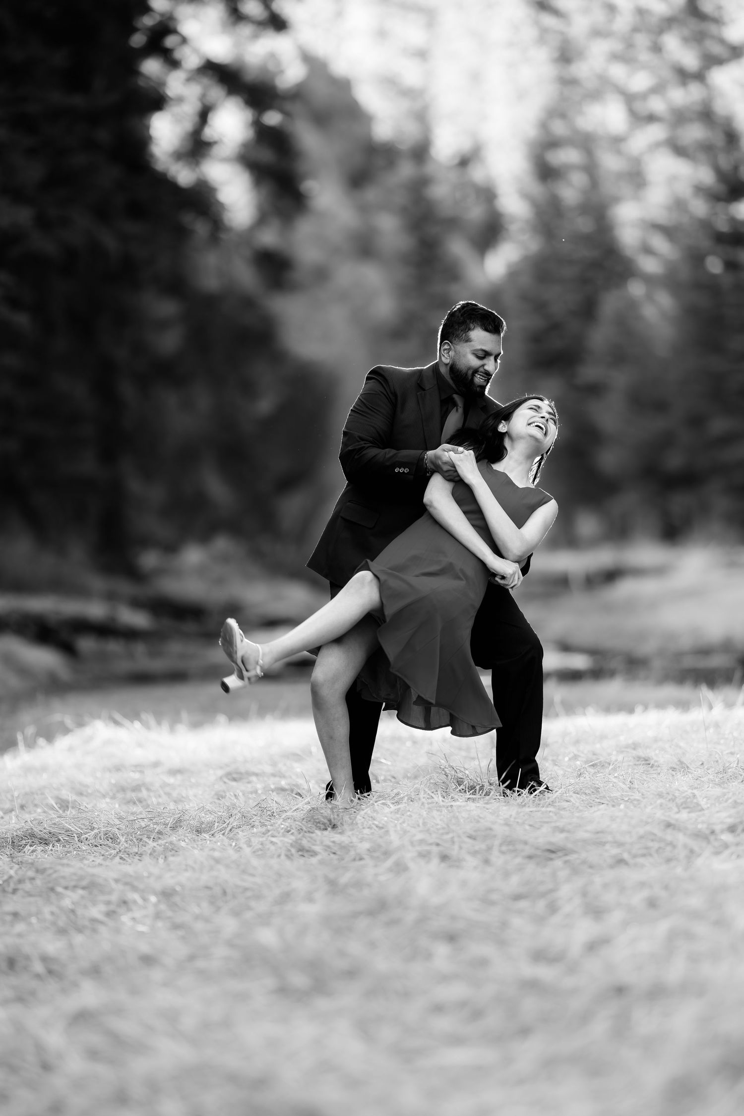 A romantic black and white dance pose captured in a natural outdoor setting.