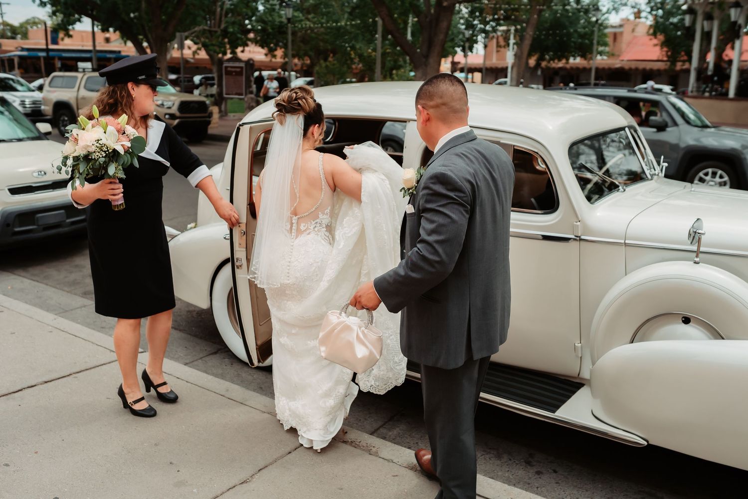 Elegant wedding scene featuring a pristine white classic car parked outside.