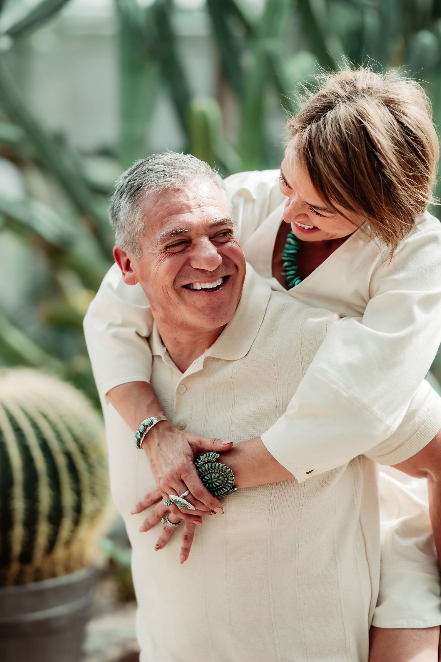 Candid shots of a couple laughing and embracing in a botanical garden setting with cacti in the background.