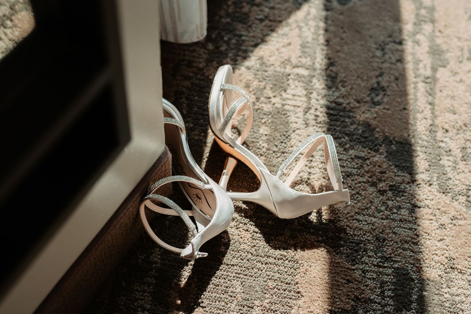 White headphones laying on textured grey carpet in natural lighting.