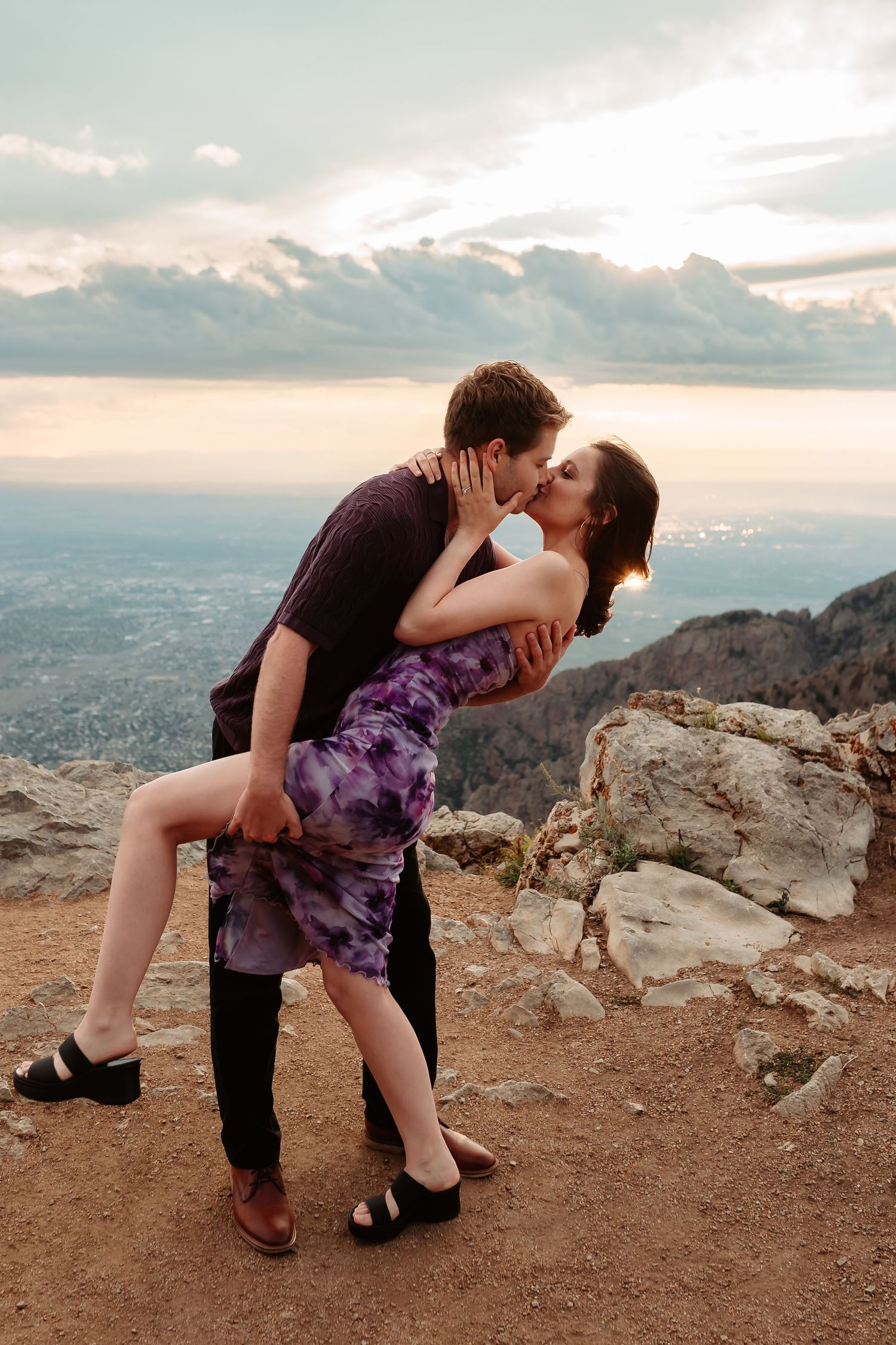 A passionate dance dip pose against a dramatic mountain sunset backdrop.