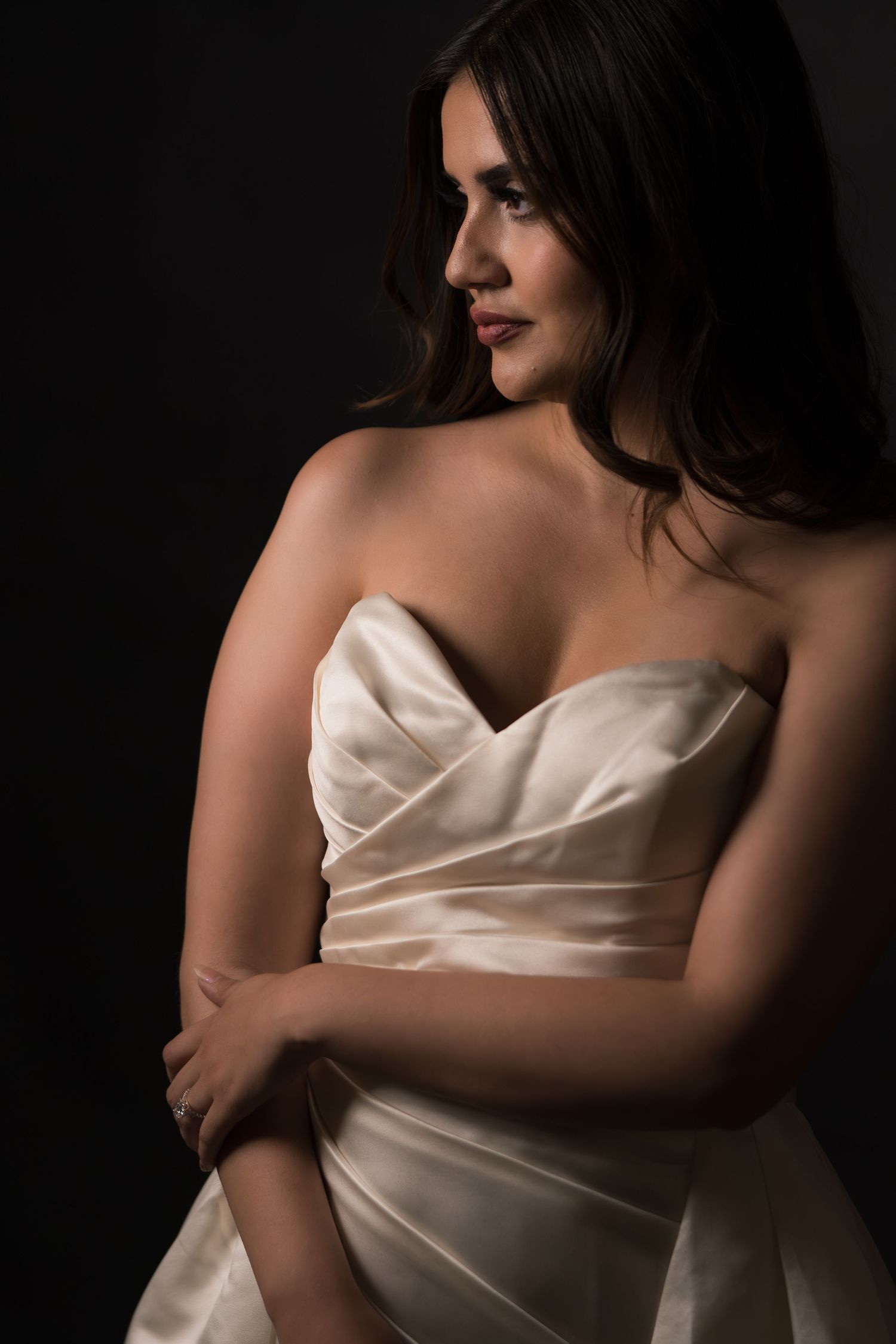 Artistic black and white portrait series showing elegant poses in white satin fabric against dark background.