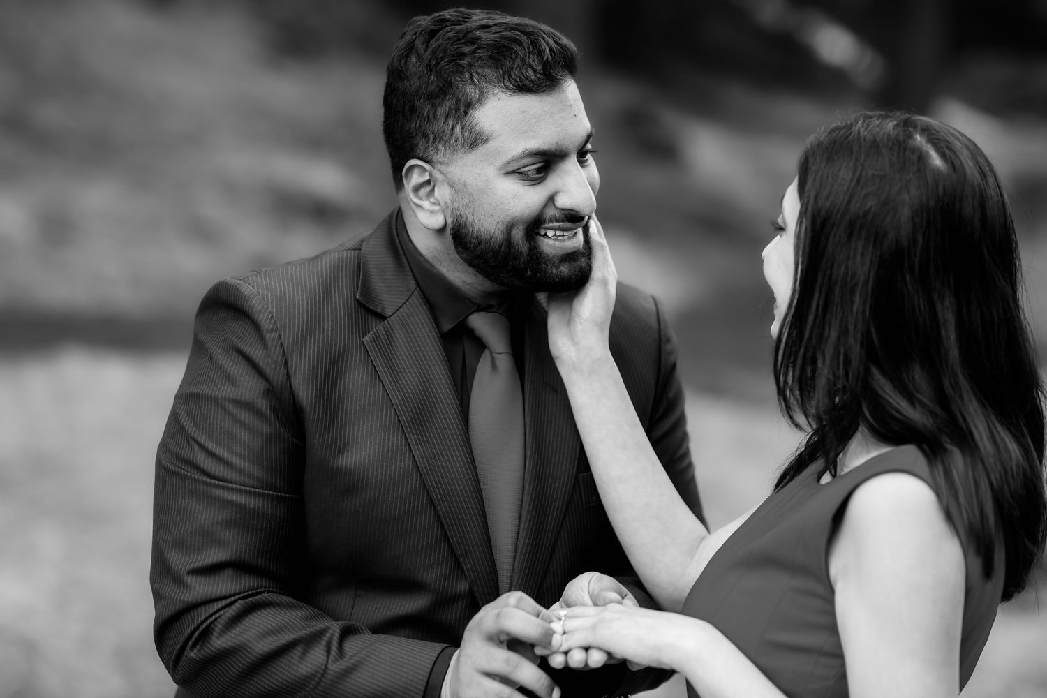 An intimate black and white engagement photo showing a tender moment.