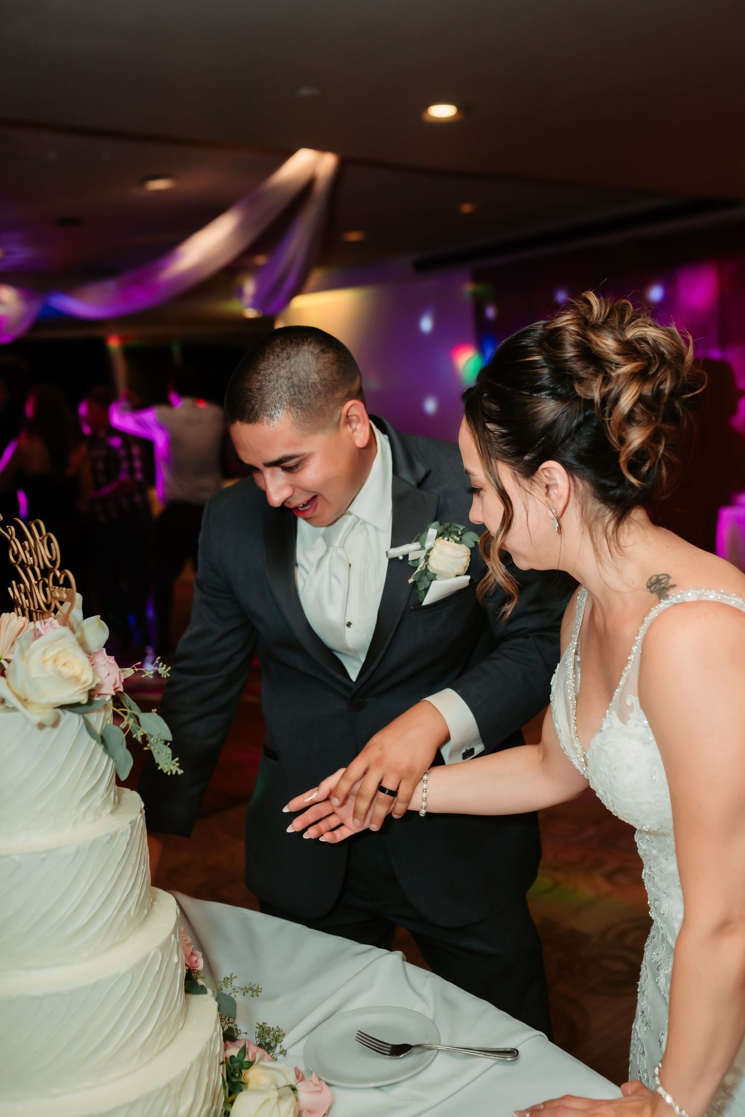 Newlyweds prepare to cut their wedding cake together during the reception celebration.