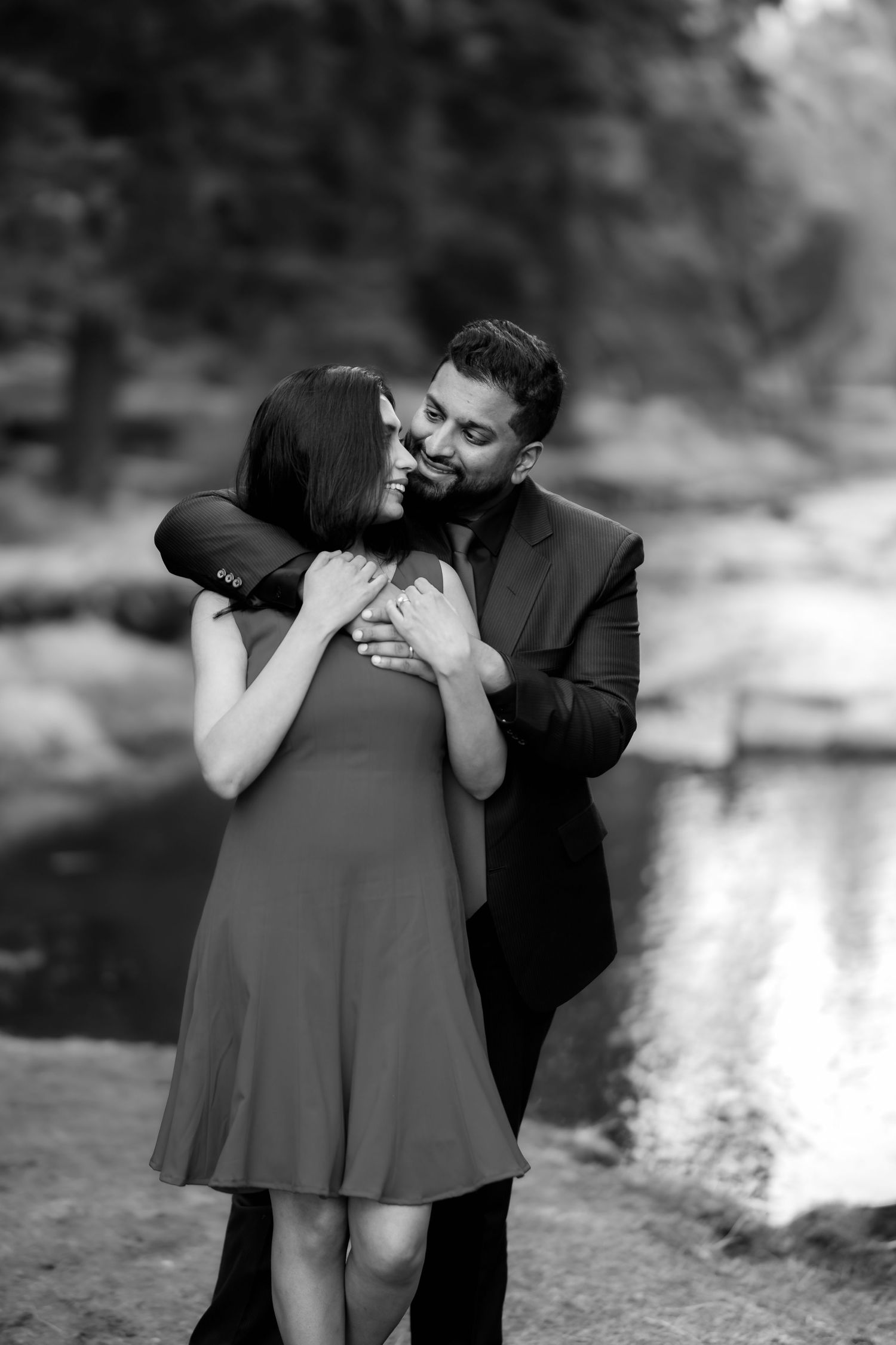 Intimate black and white portrait of couple embracing outdoors.