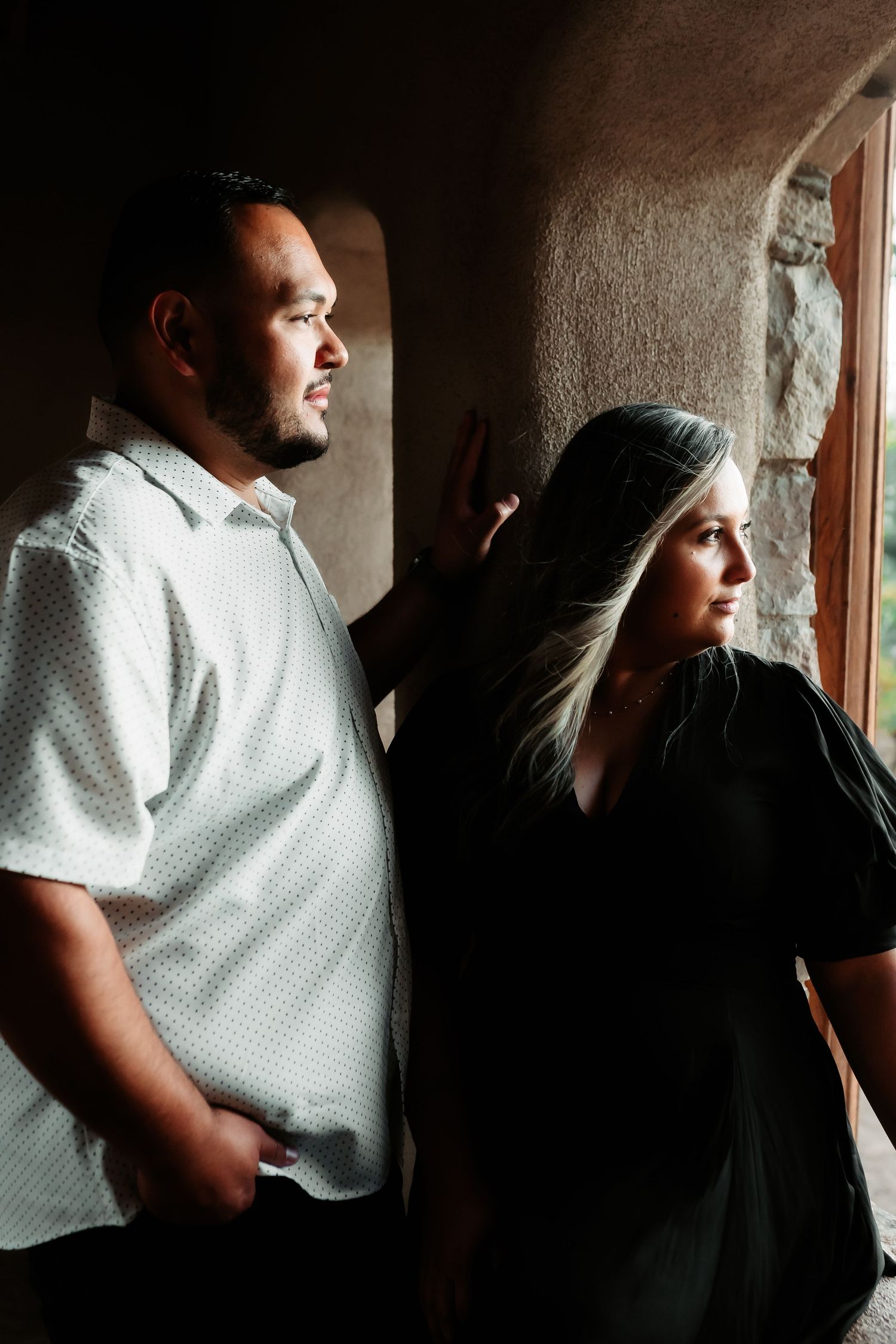 A series of moody profile shots showing two people in white and black clothing against a shadowy interior background.