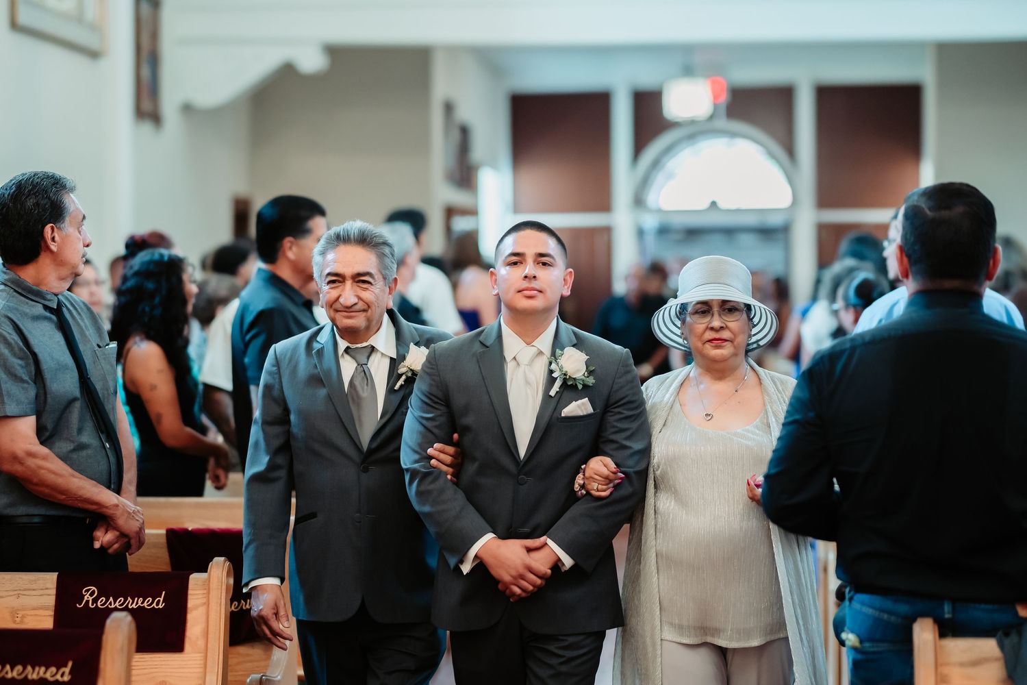 Wedding guests react with joy and laughter during what appears to be an emotional reception moment.