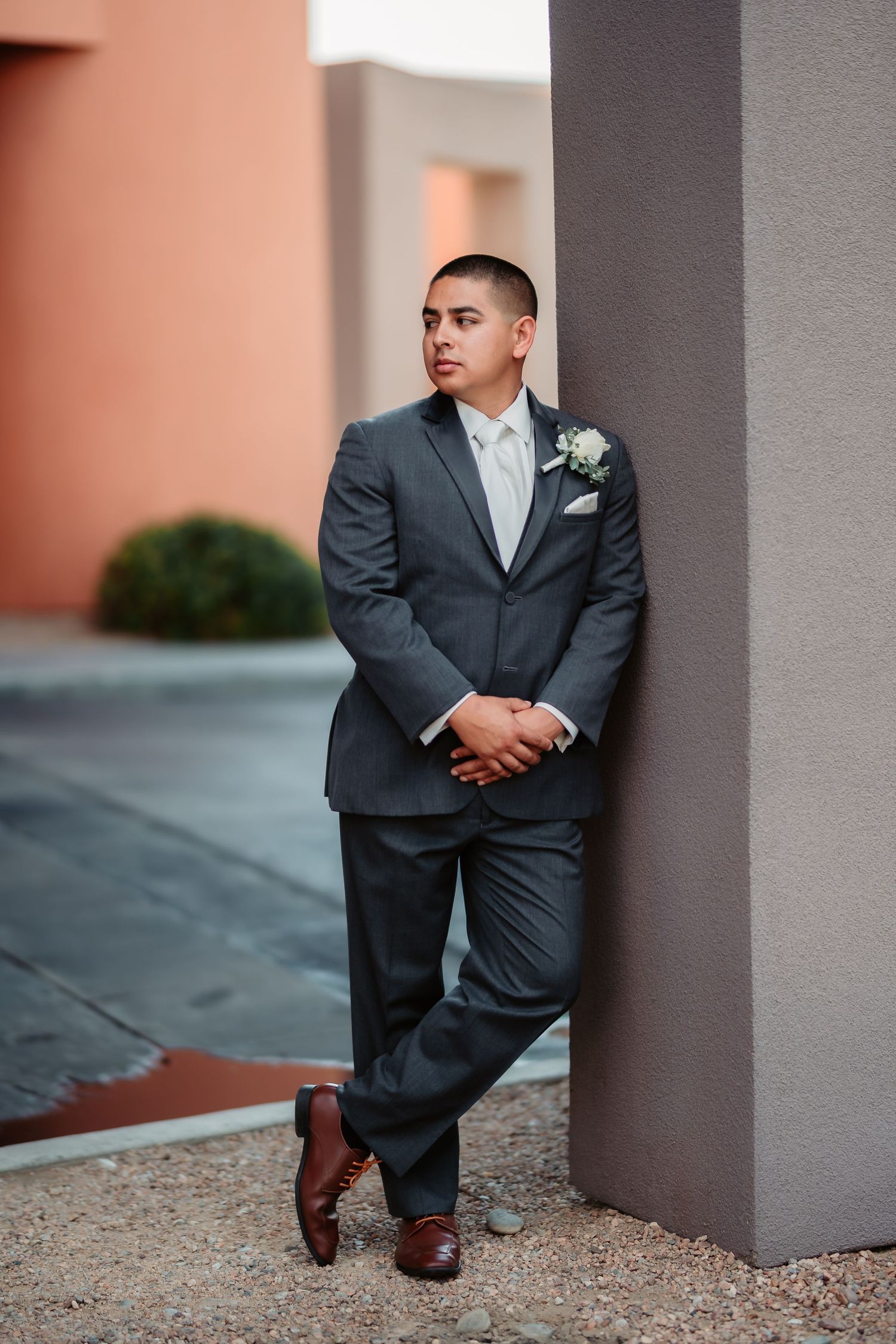 Formal portrait series between concrete columns showing full suit and dress shoes in varied poses.