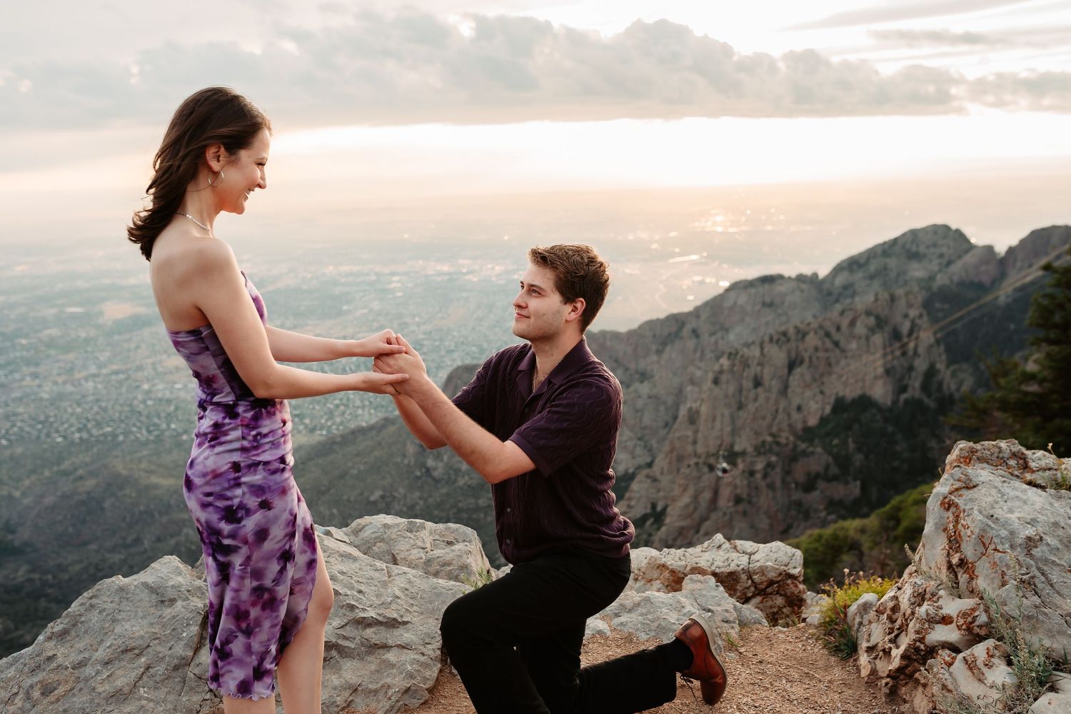 A heartfelt marriage proposal scene against a dramatic mountain landscape backdrop.