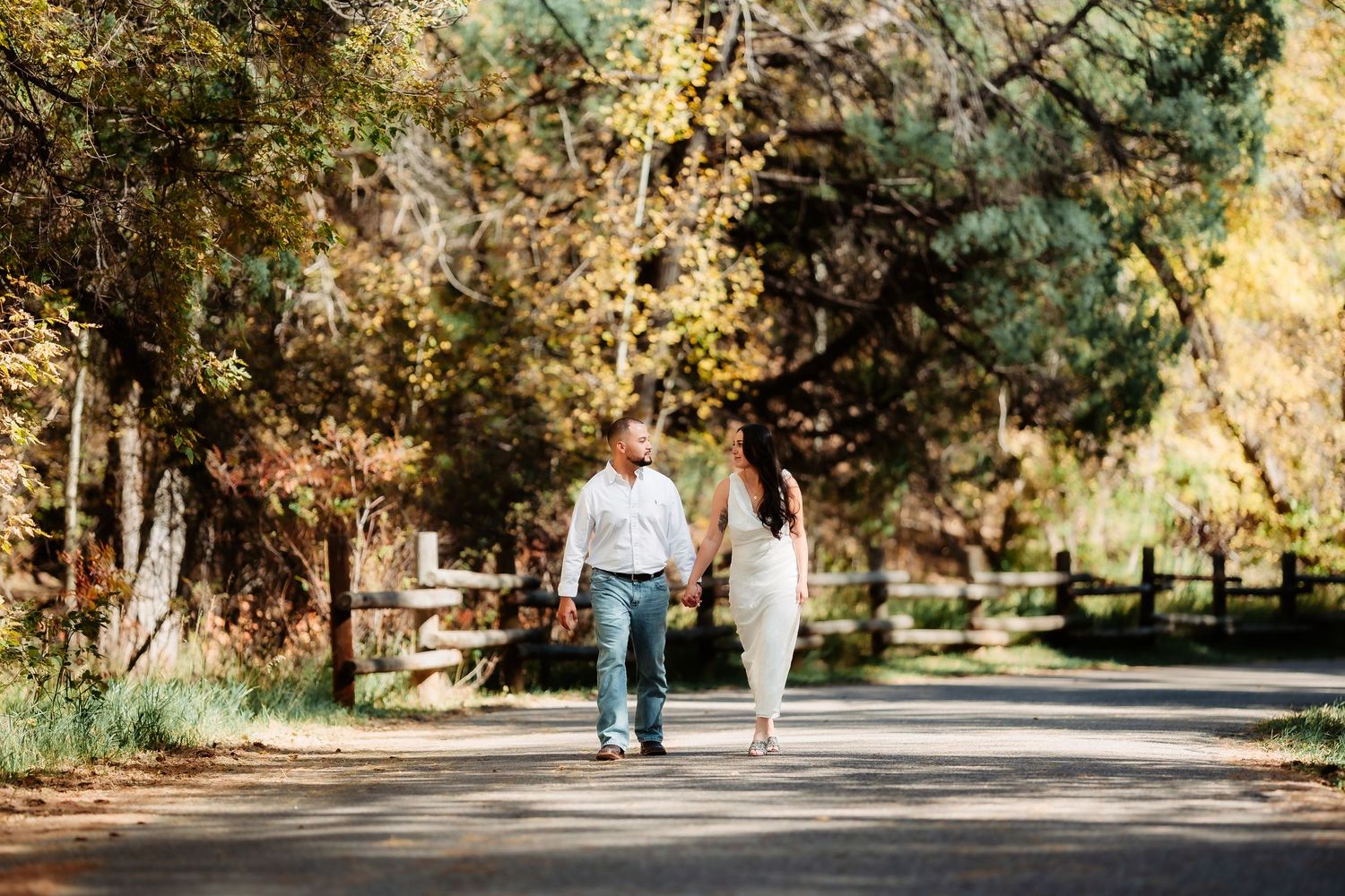 Romantic outdoor engagement photoshoot in a park with golden autumn foliage.
