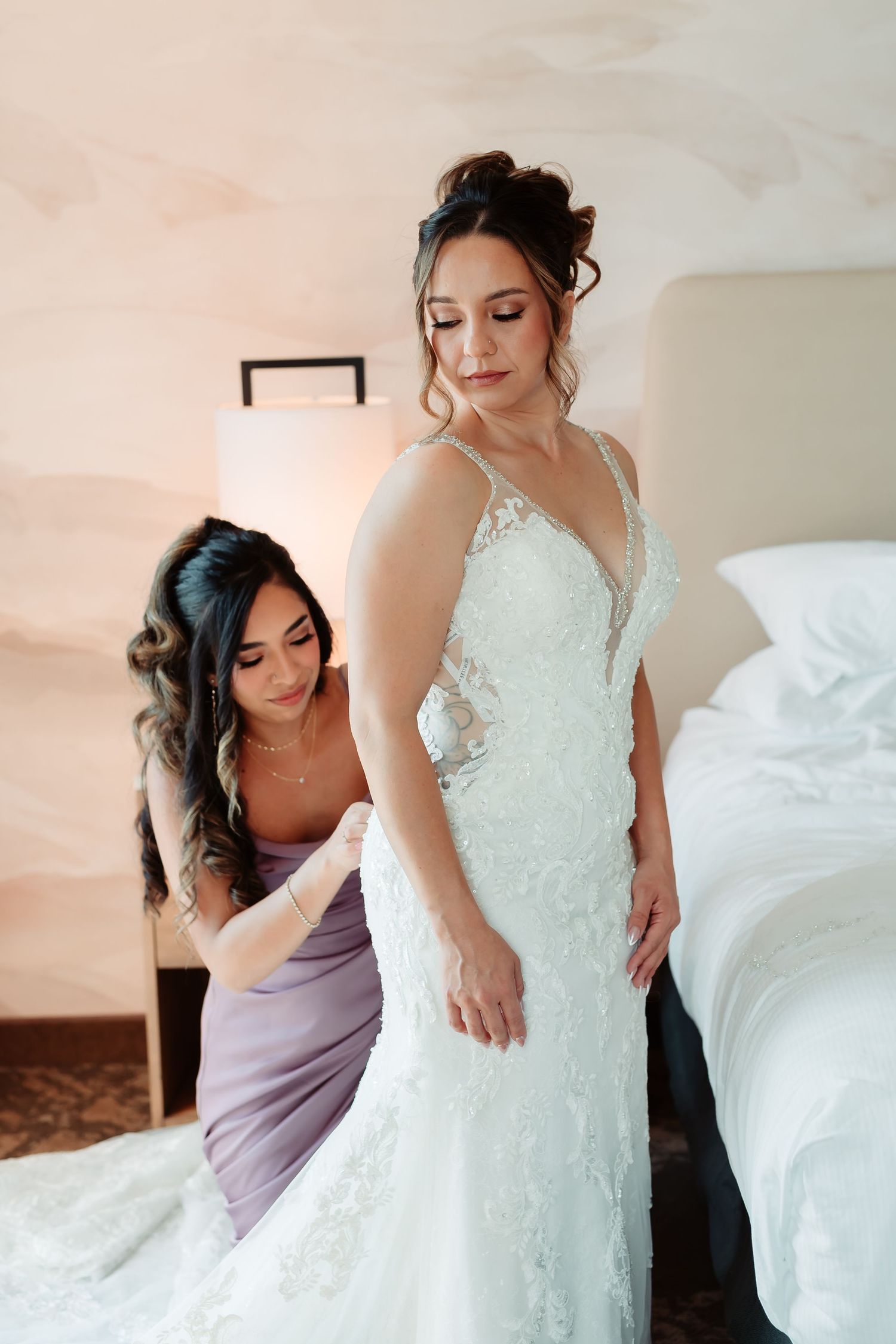 Wedding dress fitting session showing detailed lace bodice against soft natural lighting.