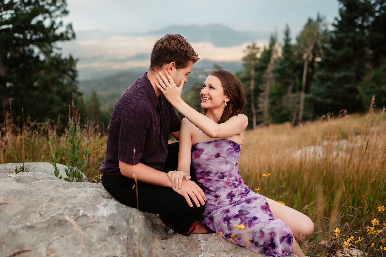 Intimate moments captured between couple on rocky mountain terrain at sunset.