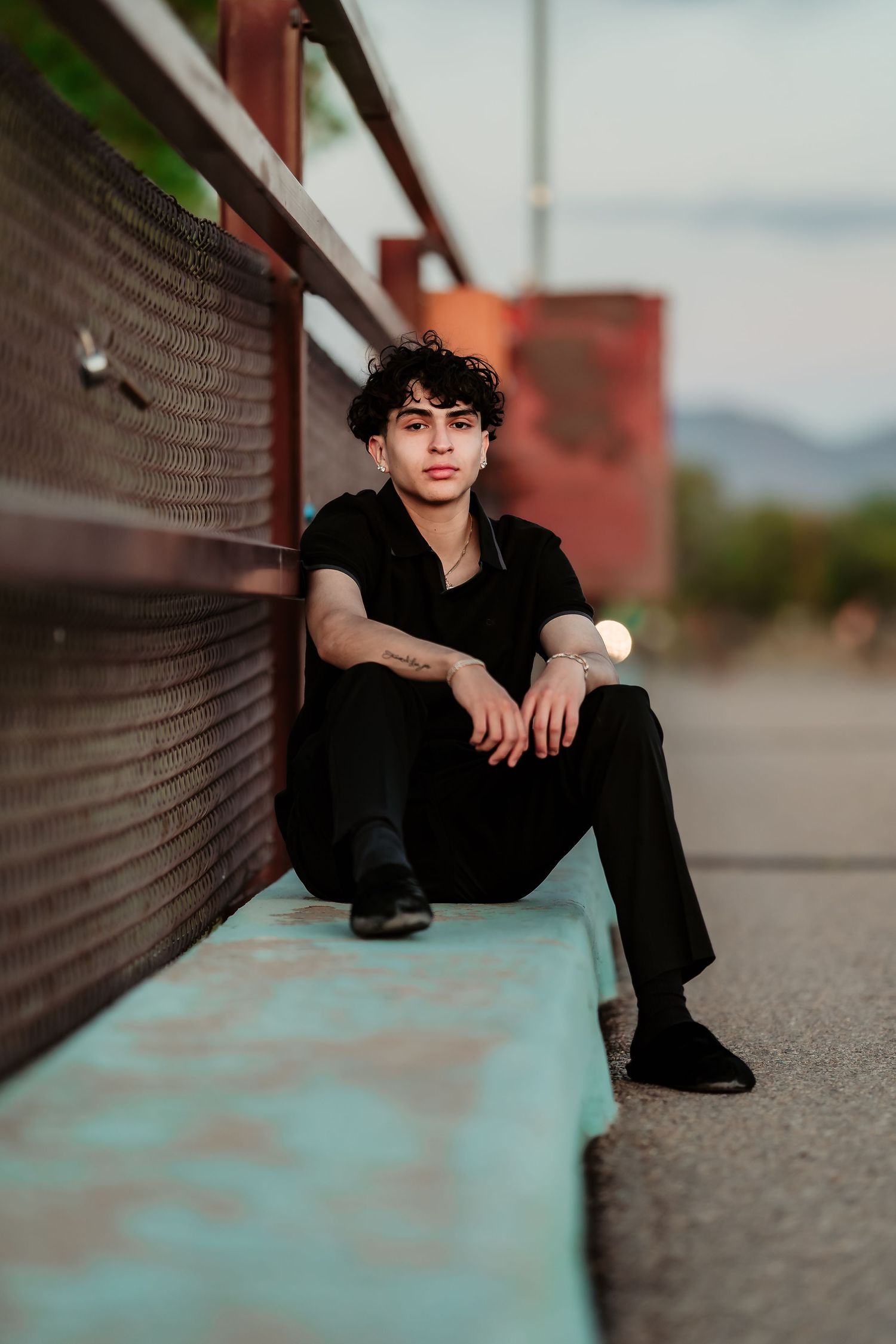 Modern casual outfit photographed against turquoise bench and industrial backdrop.