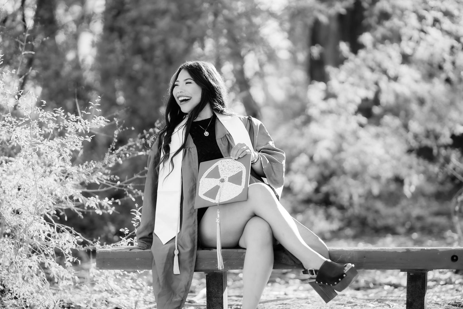 Black and white portrait series featuring a subject in casual attire posing outdoors against natural backgrounds.