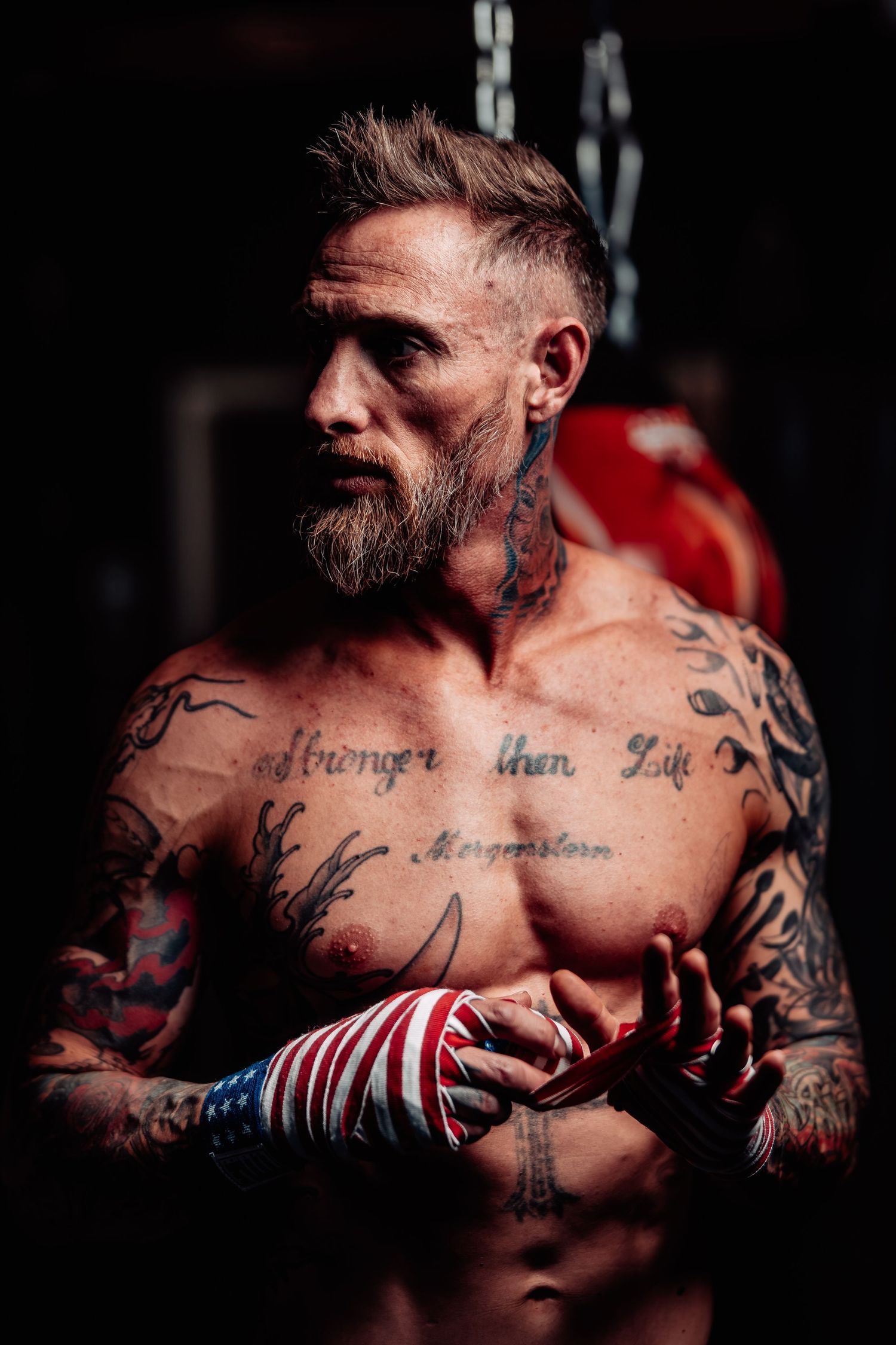 A dramatic series of black and white portraits showing a muscular tattooed torso against a dark background.