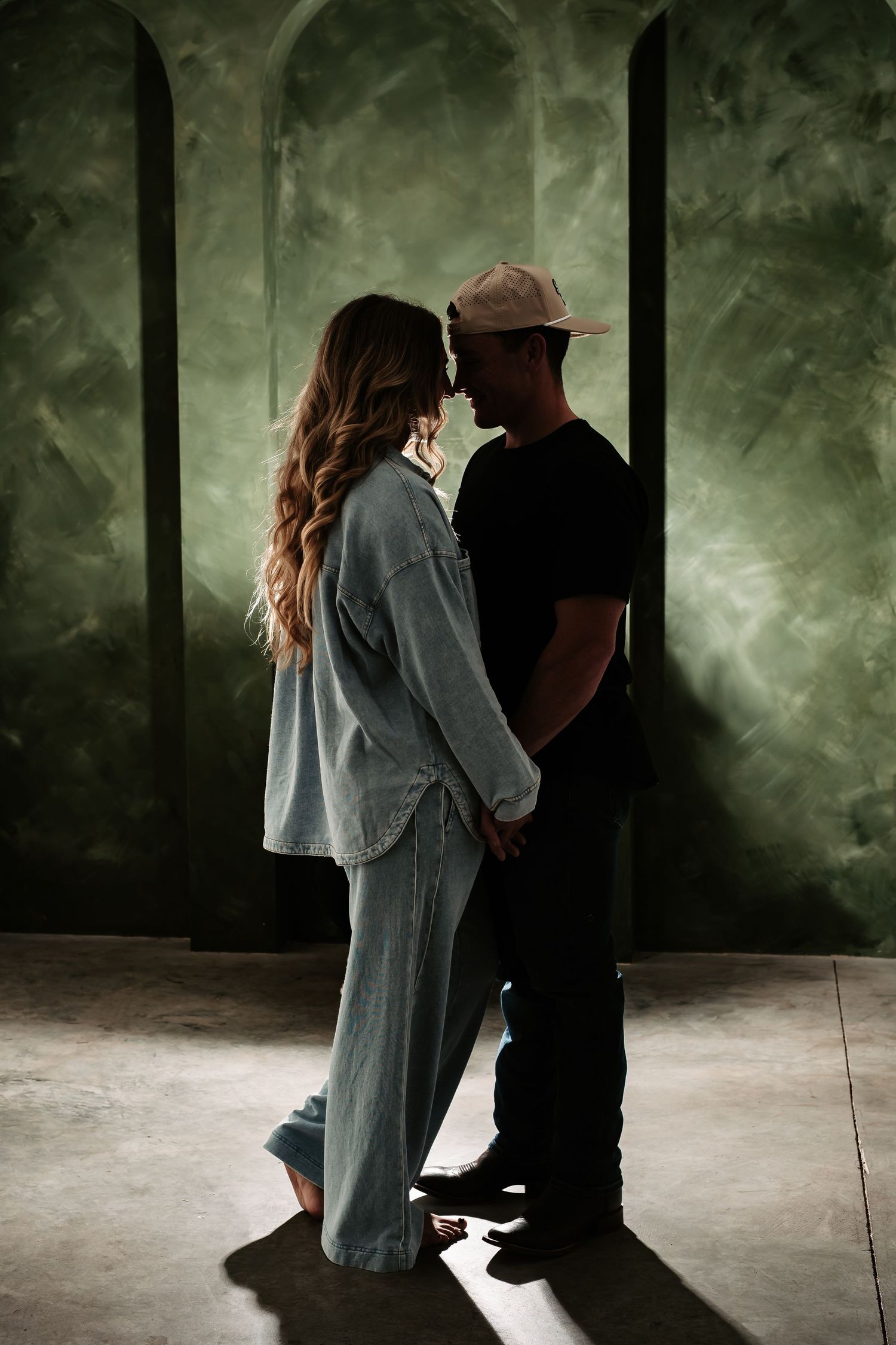 Two silhouettes dance gracefully together in a misty studio with dramatic lighting and smoke effects.