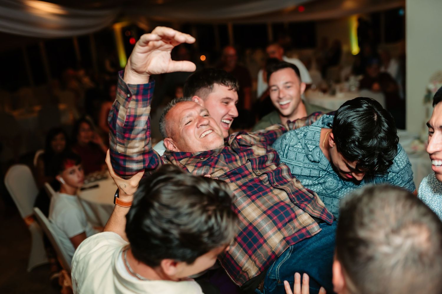 Wedding guests celebrating enthusiastically during a reception dance party.