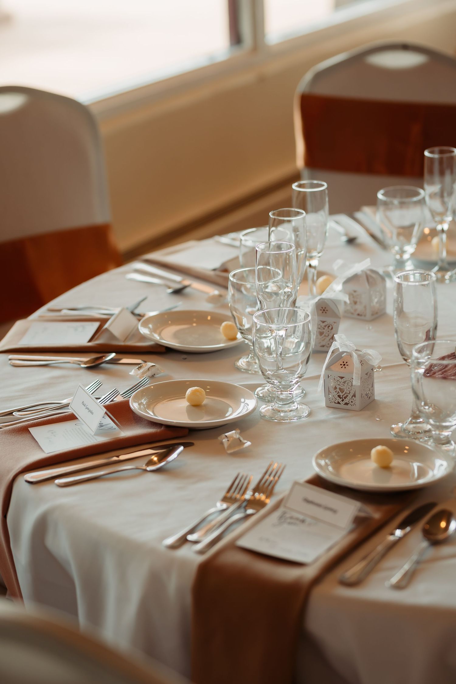 Elegant table settings with white linens, glassware and place settings at a formal dining venue.