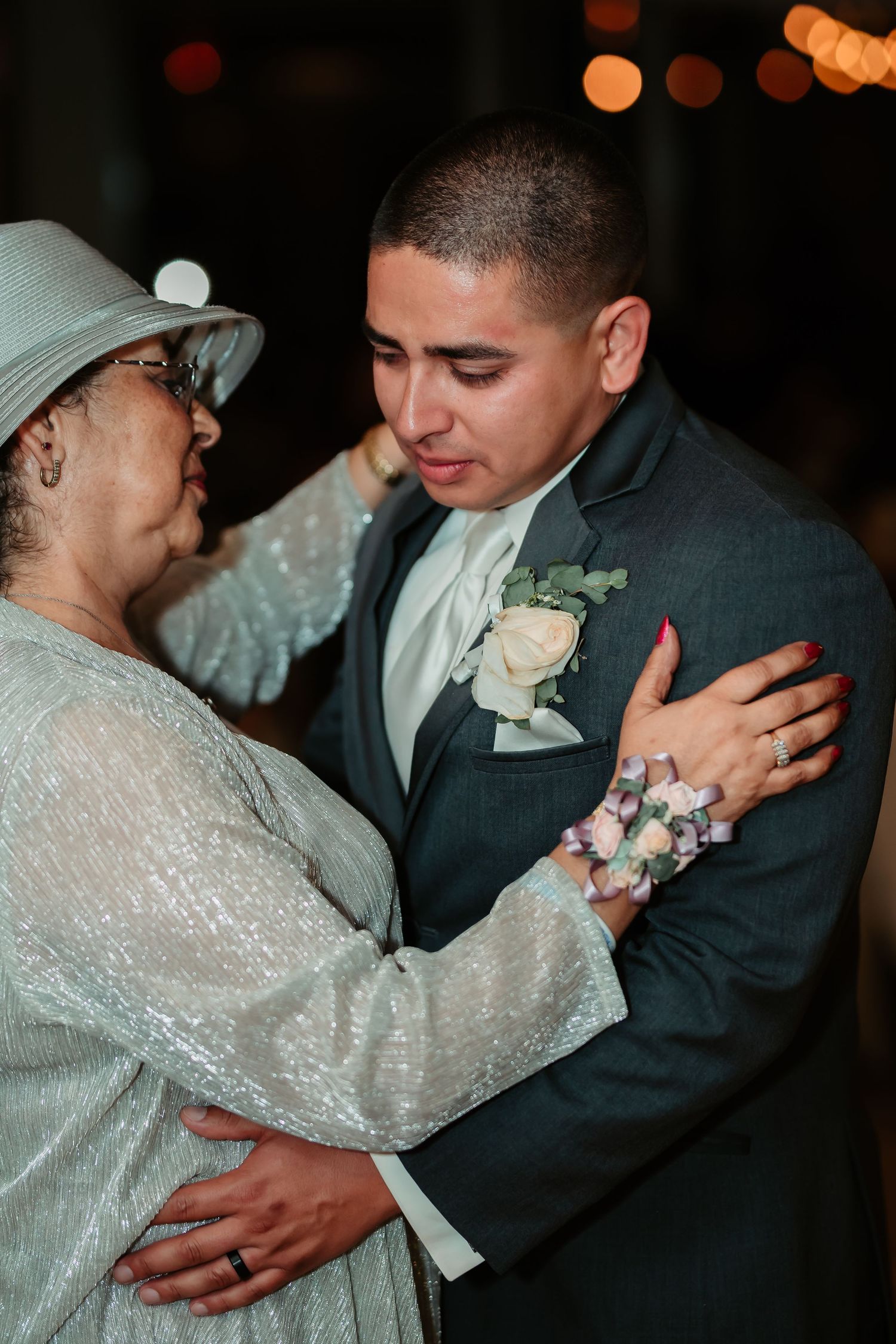 Tender wedding reception dance moments captured in dim lighting with glowing bokeh effects.