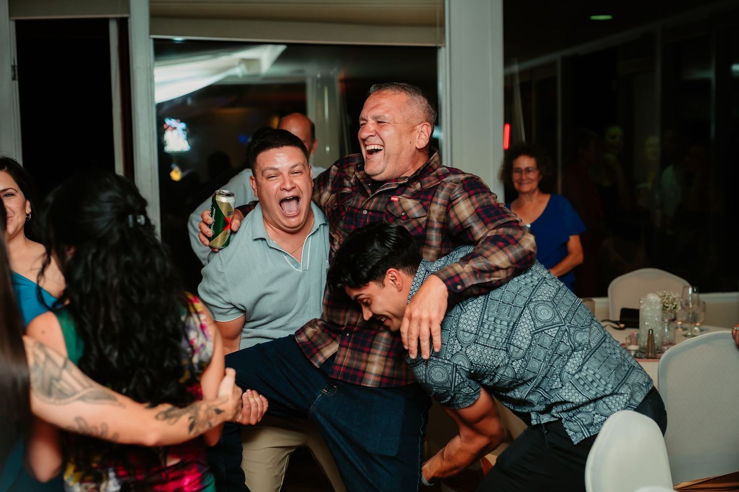 Wedding guests laughing and having fun during a group dance moment.