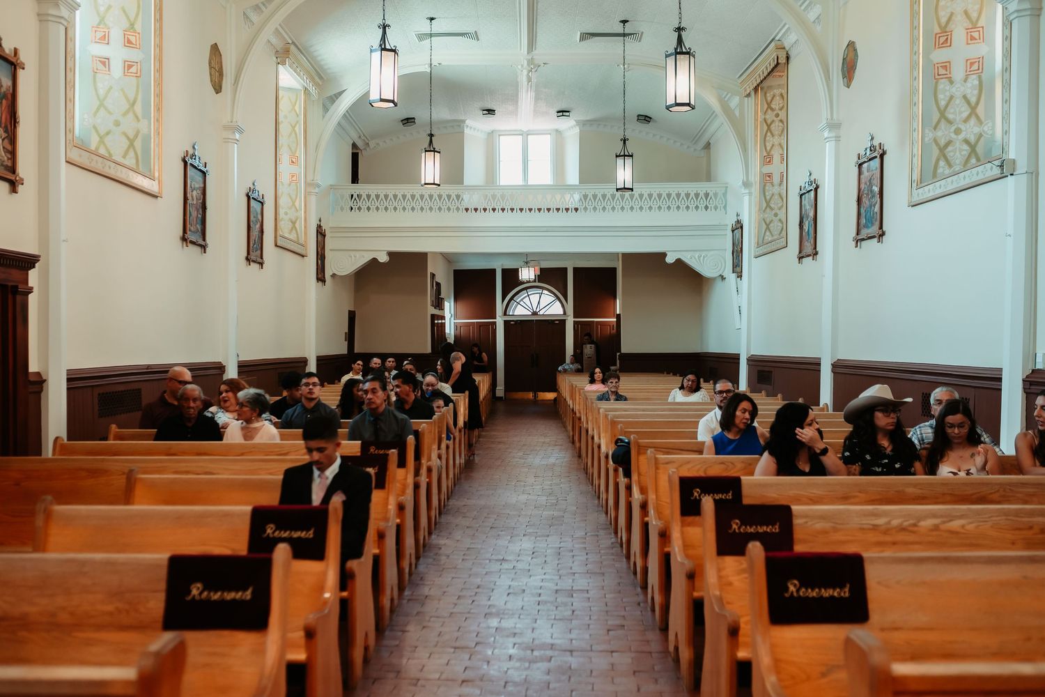 Interior view of a classic church sanctuary with wooden pews and ornate architectural details along the walls and ceiling.