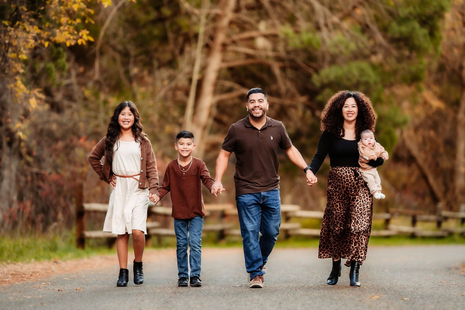 Family members walking together on a path through autumn trees in a series of connected photos.