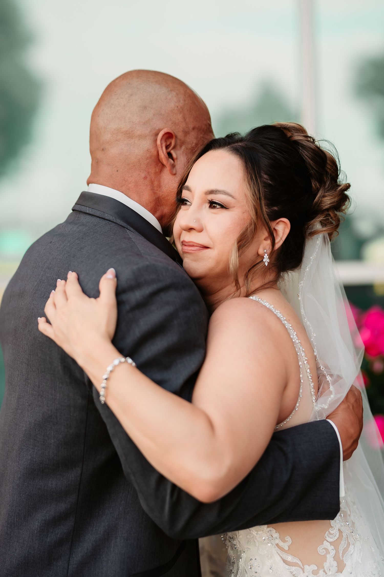 An emotional embrace between wedding couple shows tender moments between a bride in white dress and groom in dark suit.
