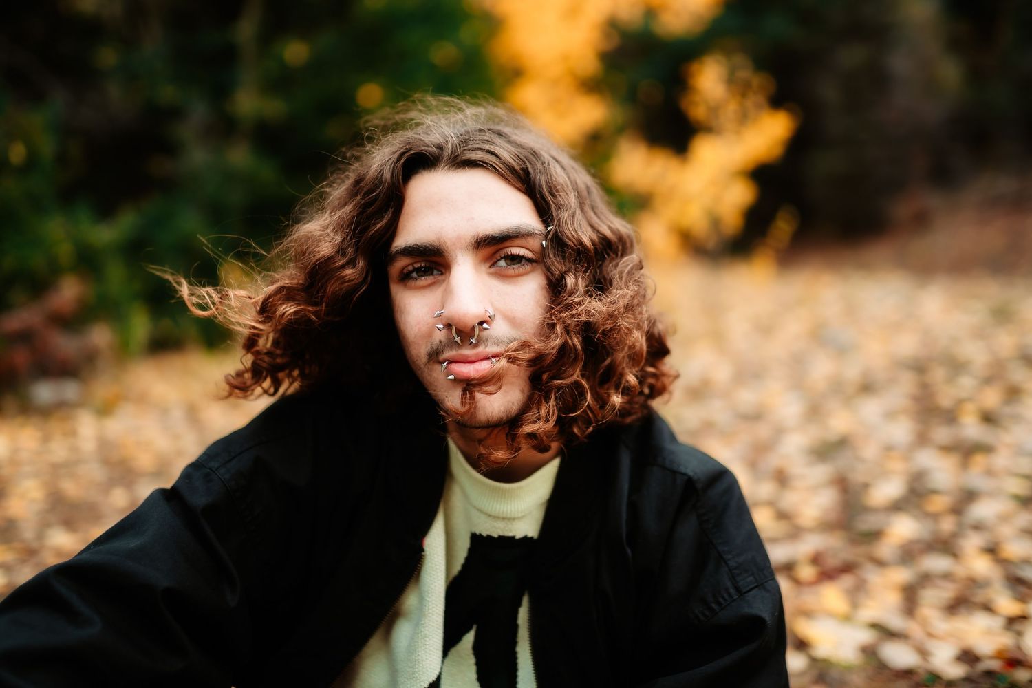 Autumn portrait session in golden sunlight with fallen leaves and natural outdoor setting.
