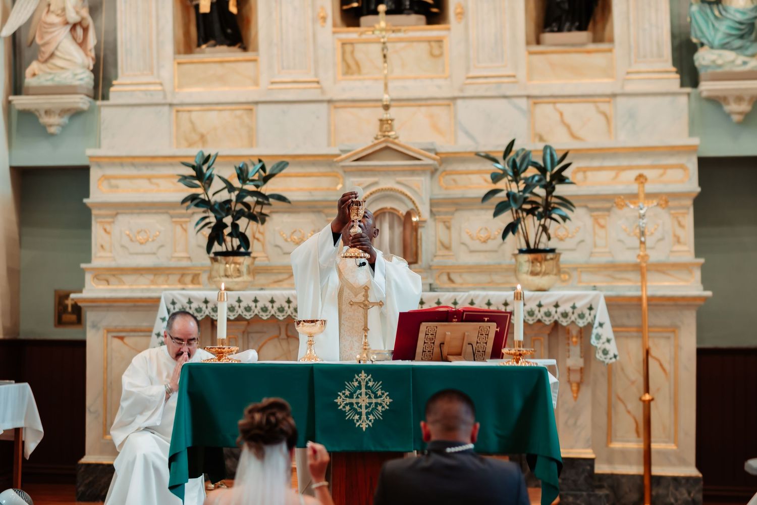 Interior view of an ornate church altar with green decorative elements and classical architecture.