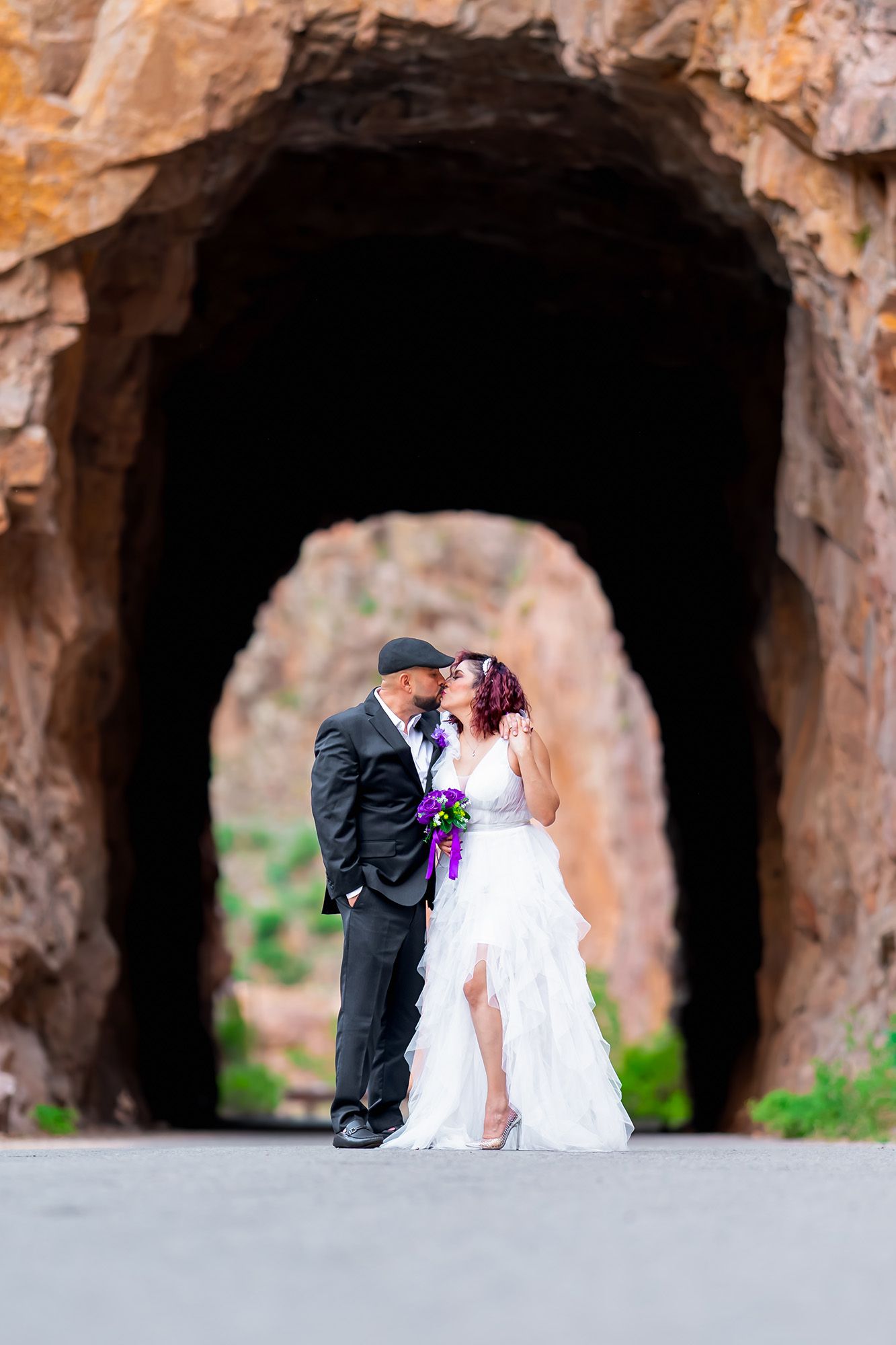 Wedding couple poses in series of stone archways at sunset creating romantic silhouette effect.
