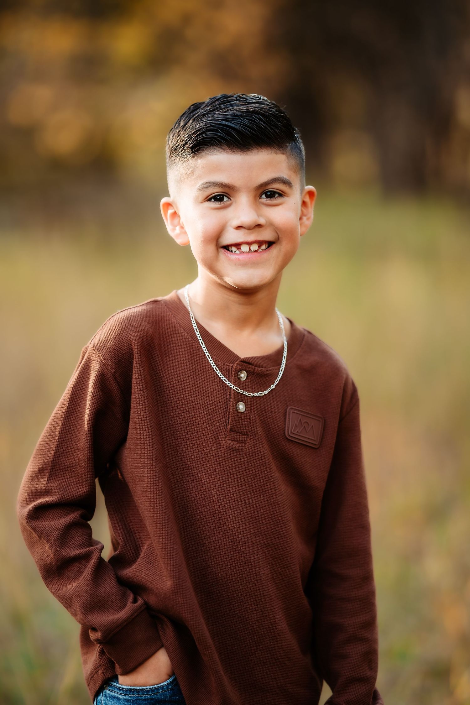 A series of outdoor portrait photos showing a child wearing a brown sweater against a blurred autumn background.