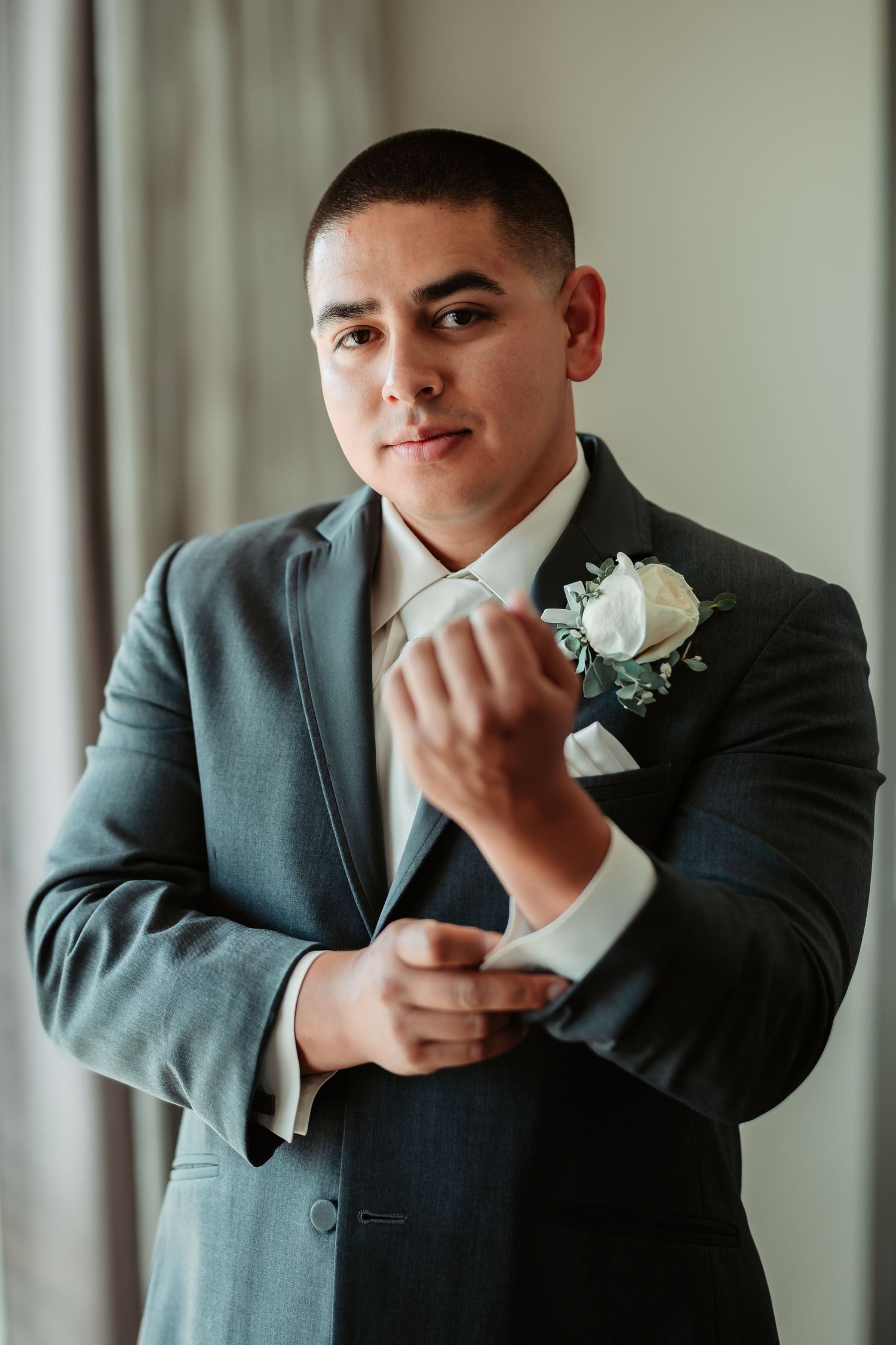 Wedding preparation sequence showing adjustments to formal attire with a white boutonniere.