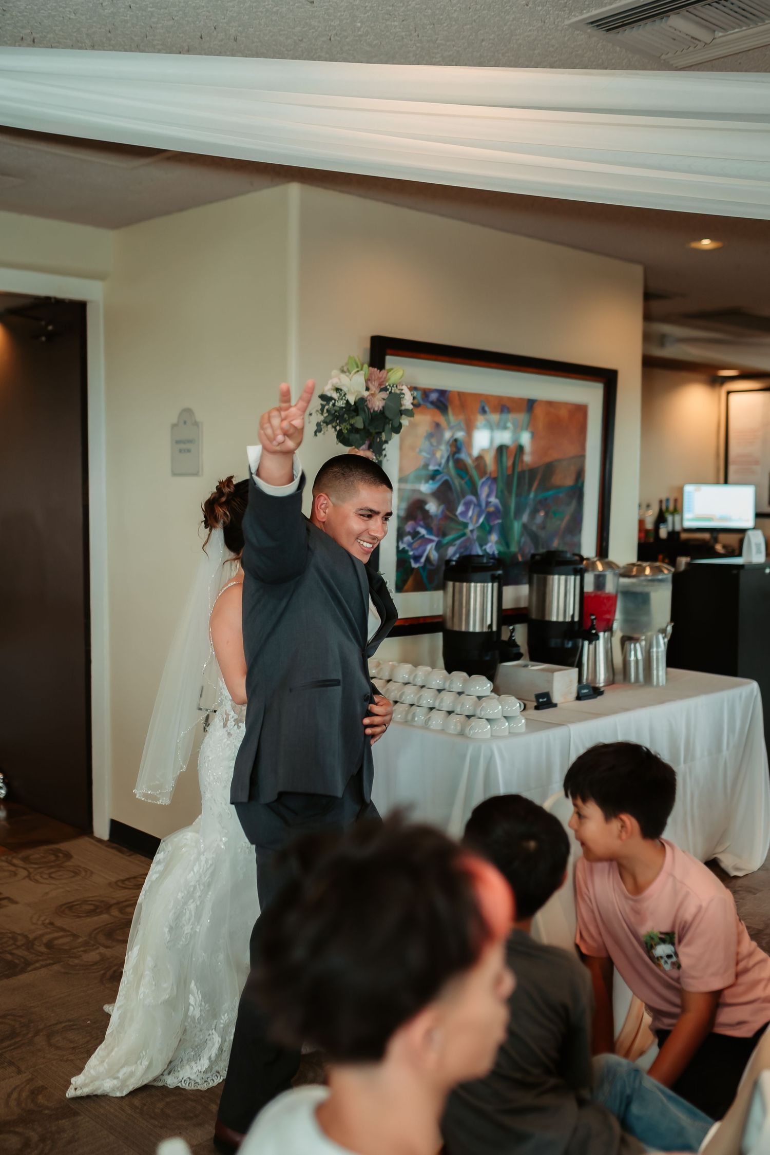 Wedding party gathers around the dance floor in preparation for dancing at an indoor reception venue.