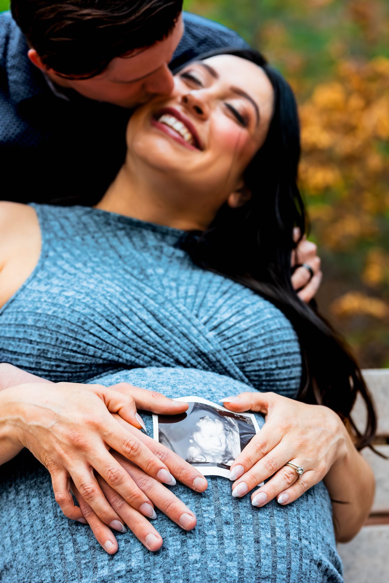 A series of photos showing hands resting on a pregnant belly wearing a blue knit sweater against an autumn background.