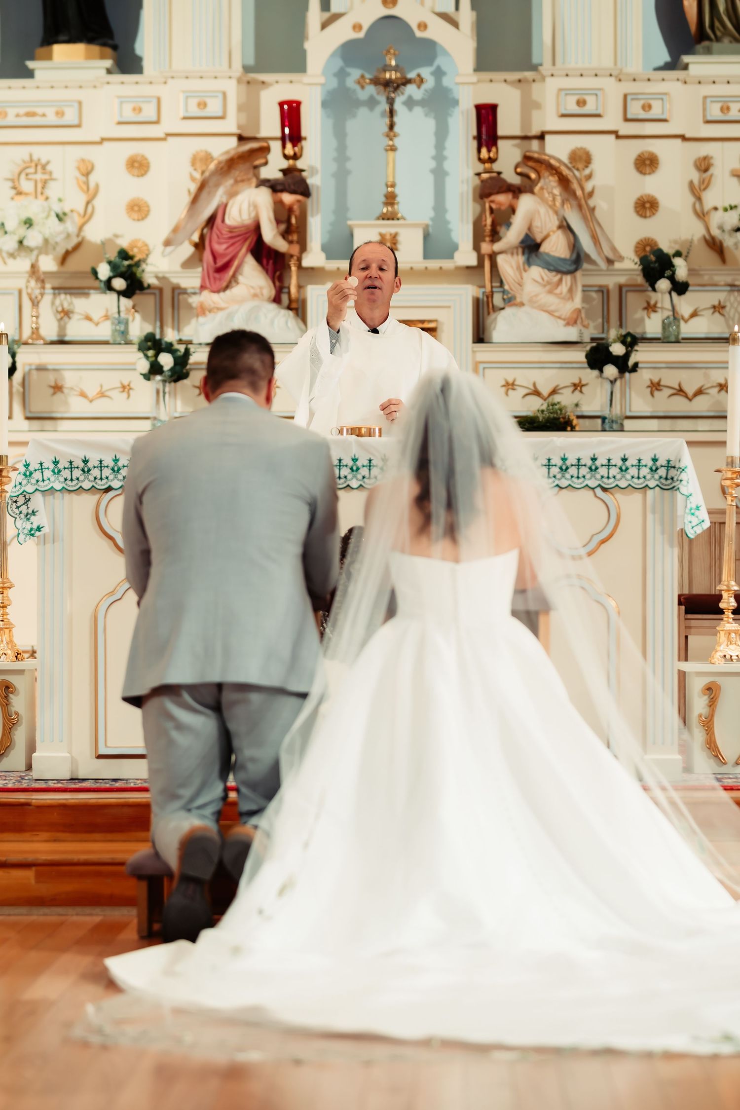 A sequence of four blurred motion shots showing a couple walking down the aisle in an ornate church during their wedding ceremony.